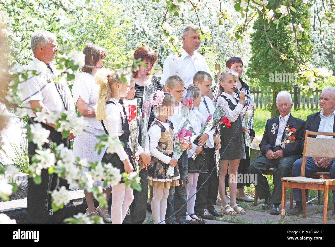 Young children congratulate the veterans of the Second World War on Victory Day. Schoolchildren and war veterans celebrate the anniversary of the end Stock Photo
