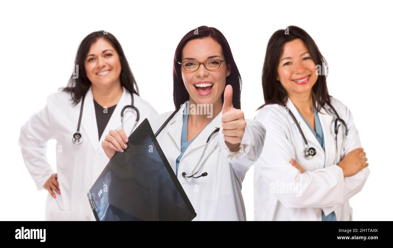 Three Hispanic Female Doctors or Nurses with Thumbs Up Holding X-ray Isolated on White. Stock Photo