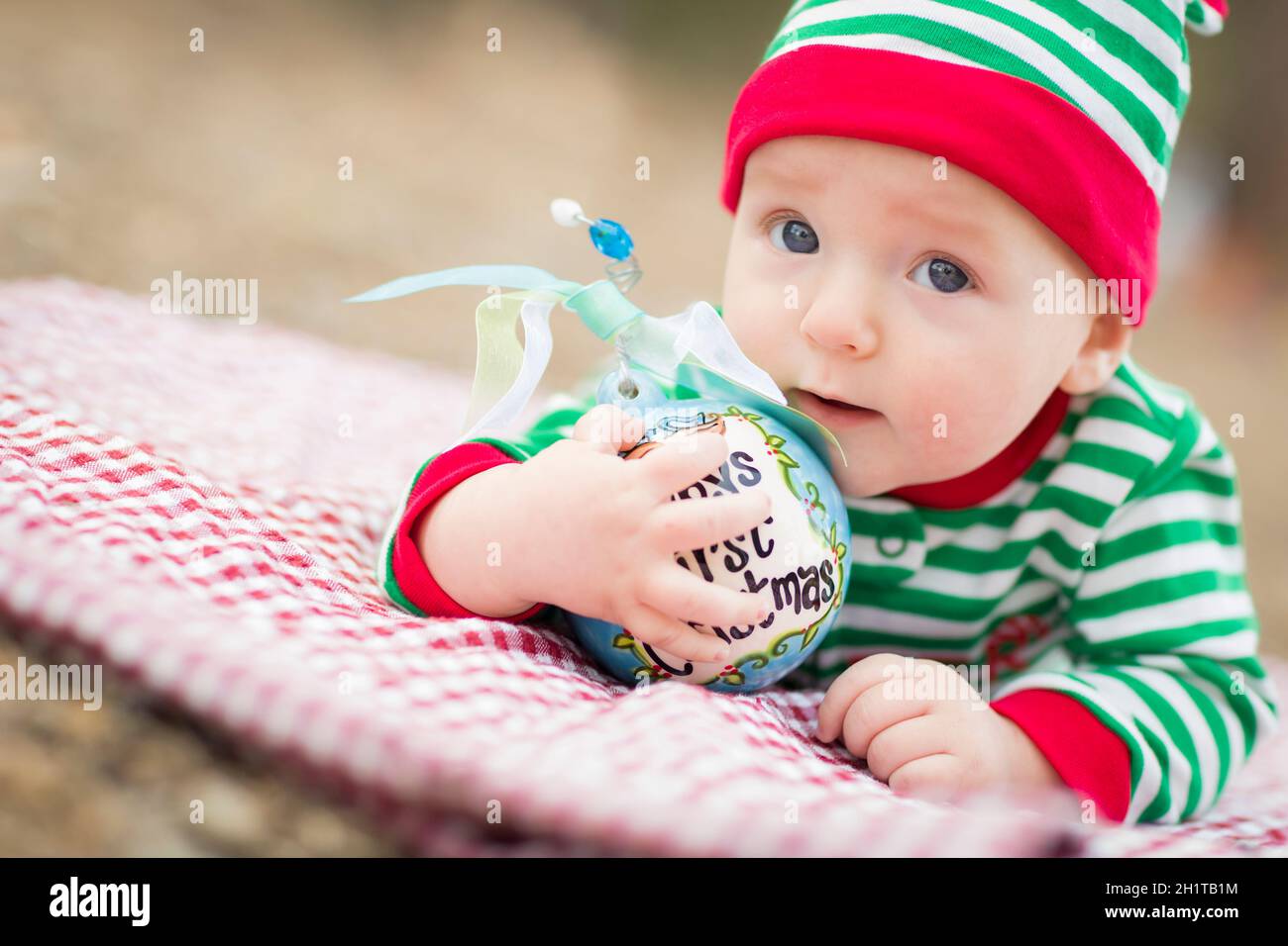 Beautiful Infant Baby On Blanket With Babys First Christmas Ornament. Stock Photo