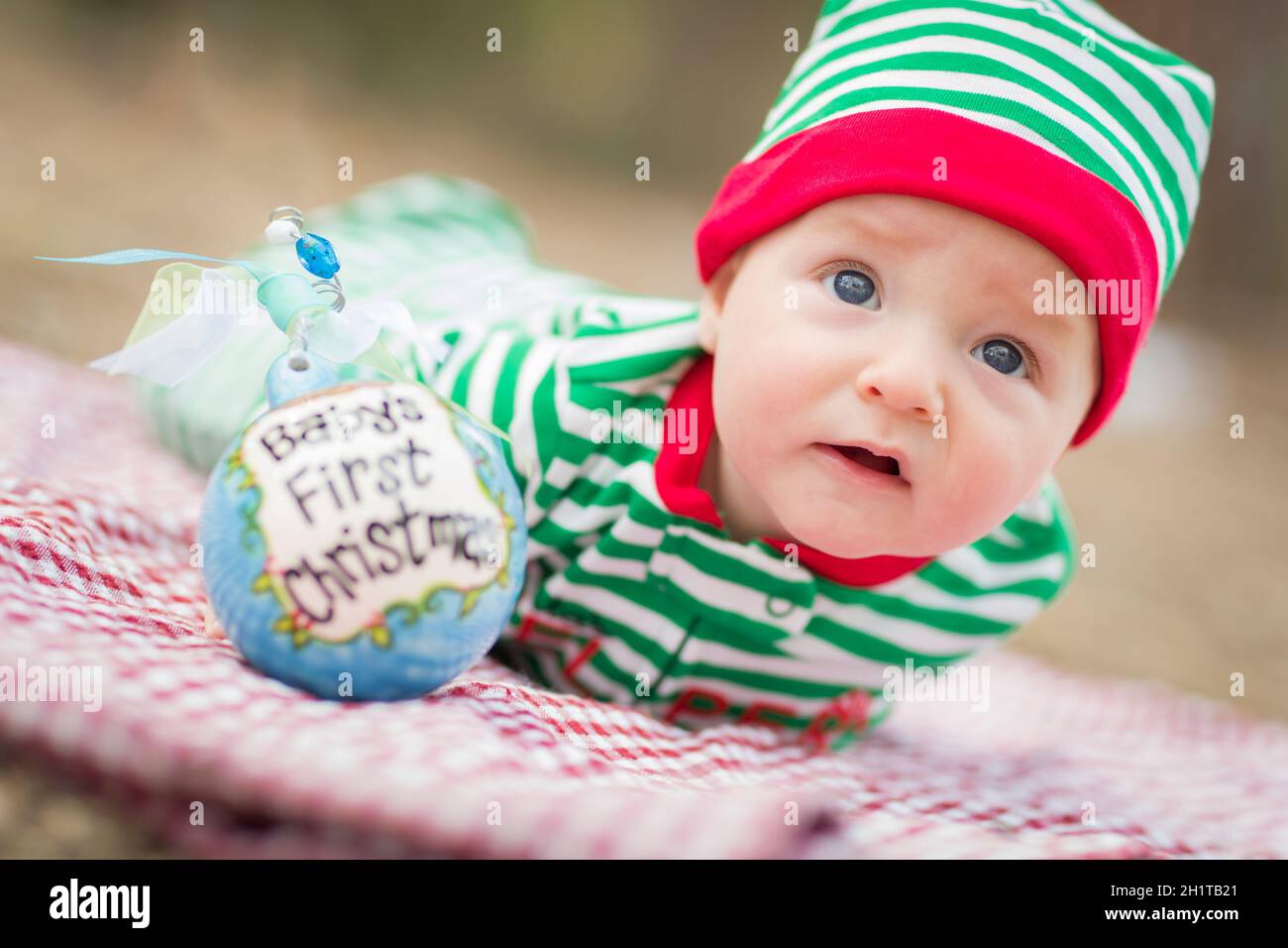 Beautiful Infant Baby On Blanket With Babys First Christmas Ornament. Stock Photo
