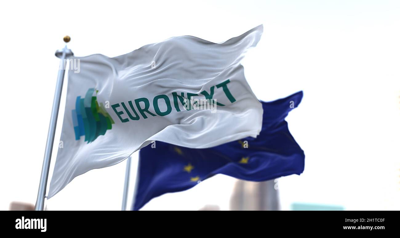 Amsterdam, HOL, April 2021: The Euronext flag flapping in the wind along with the European Union flag blurred in the background. Euronext is a stock e Stock Photo