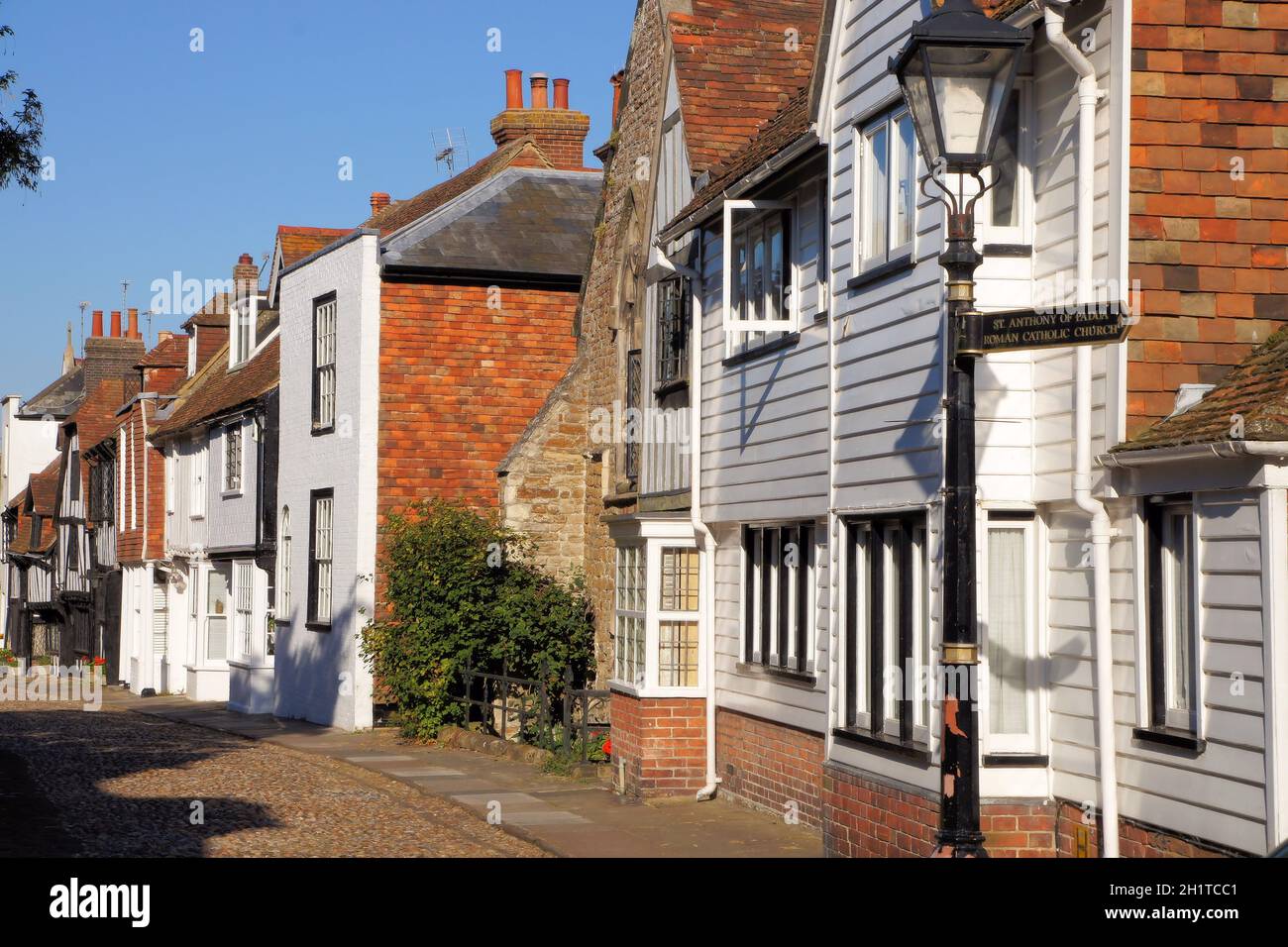 Traditional houses and lampstand on a cobblestone street in Church Square soon before sunset in Rye, East Sussex, England Stock Photo