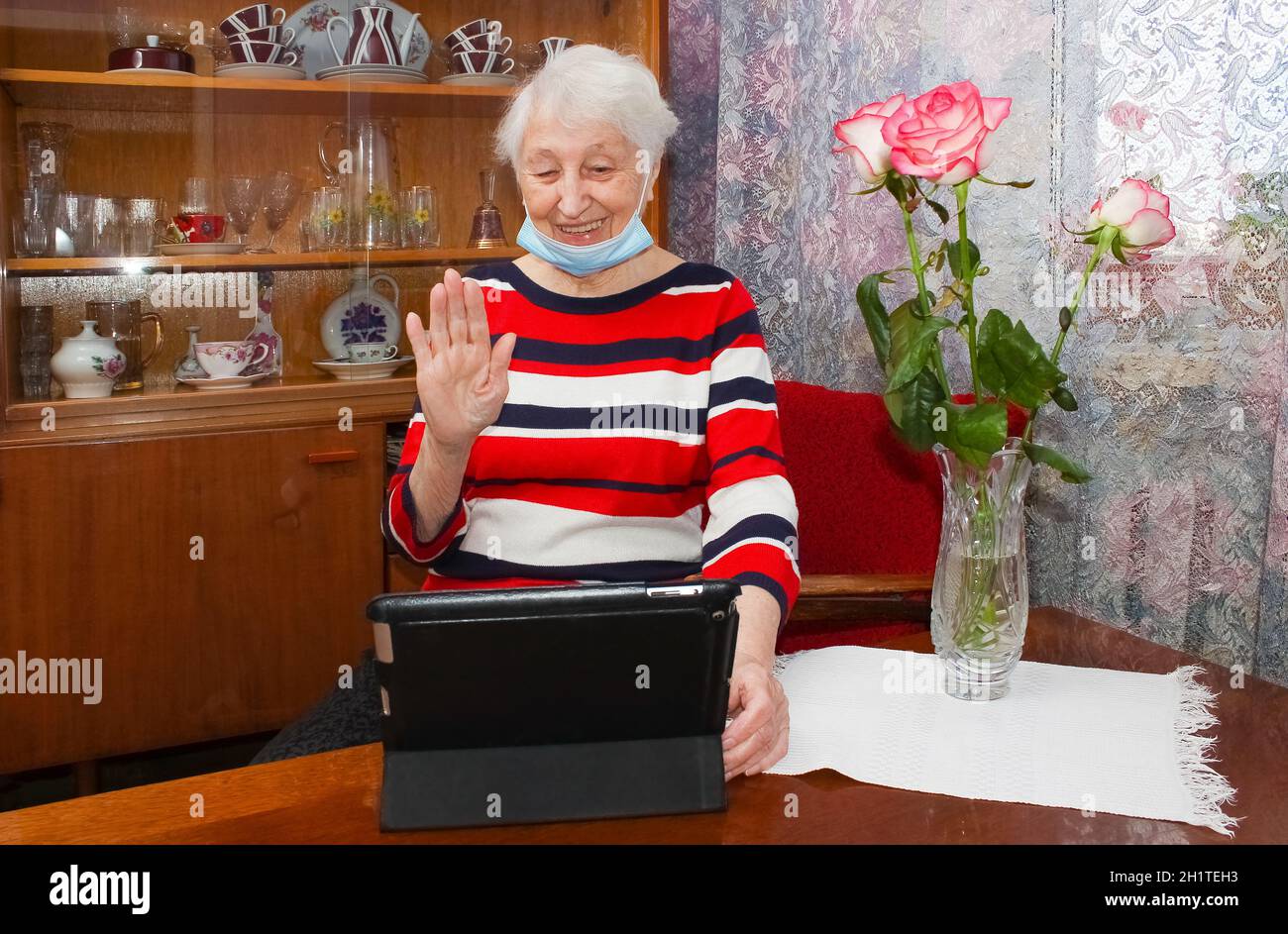 COVID-19 Stay connected. Happy senior woman at home video calling family on laptop or online chatting with long distance friends. Coronavirus lockdown Stock Photo