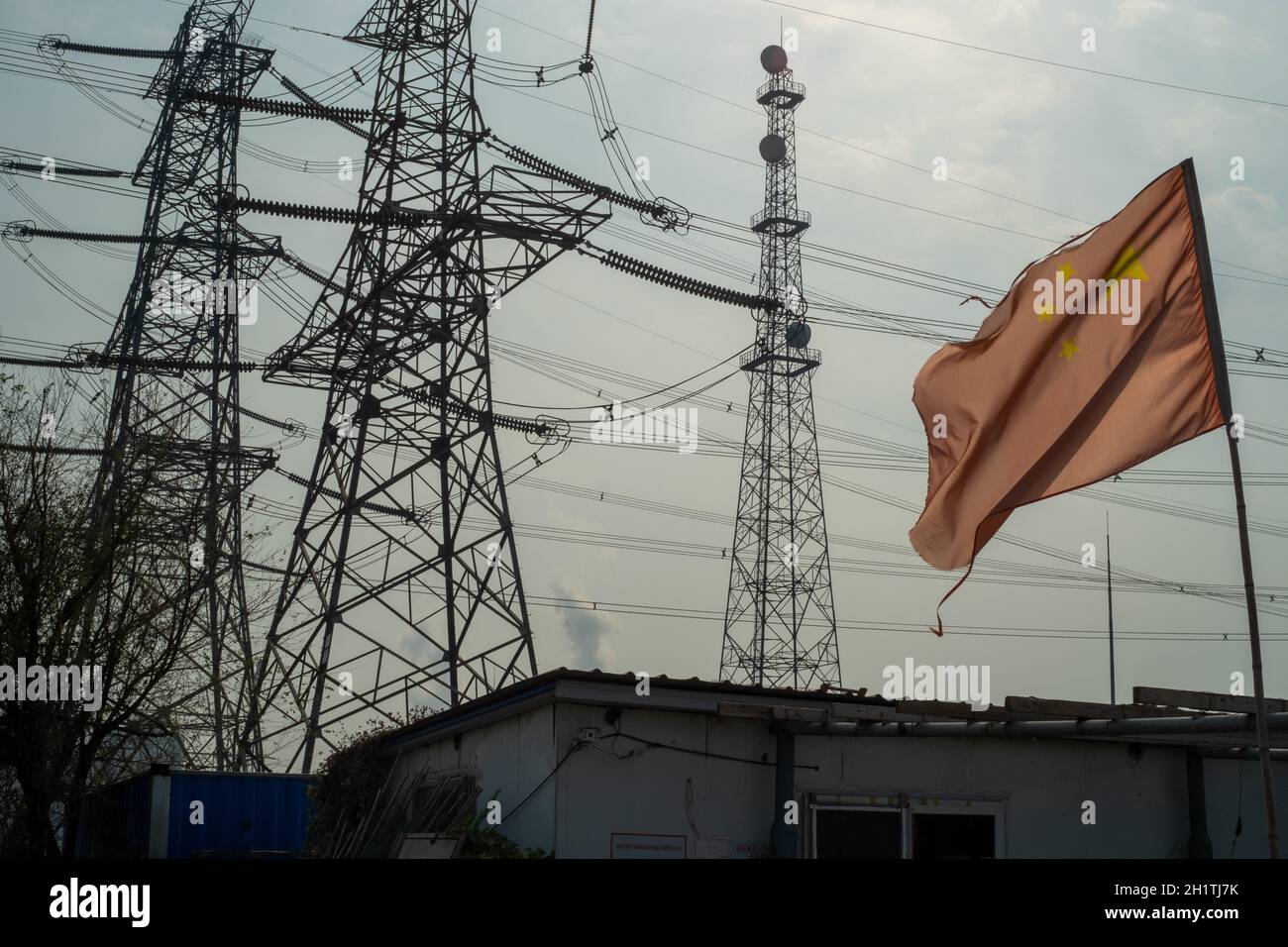 Chinese flag waving in front of high-voltage transmission towers in Tianjin, China. 19-Oct-2021 Stock Photo
