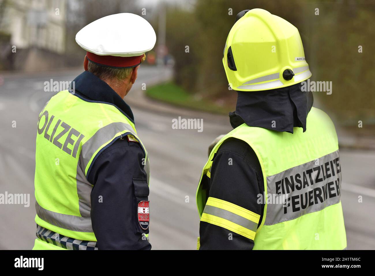 Polizist und Feuerwehrmann von hinten in Oberösterreich, Österreich, Europa - Police officer and firefighter from behind in Upper Austria, Austria, Eu Stock Photo