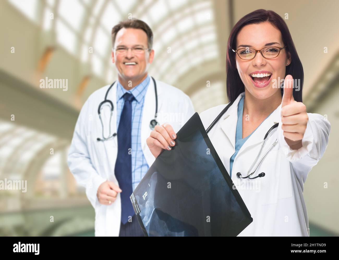 Doctors or Nurses With Thumbs Up Holding X-ray Standing Inside Hospital. Stock Photo