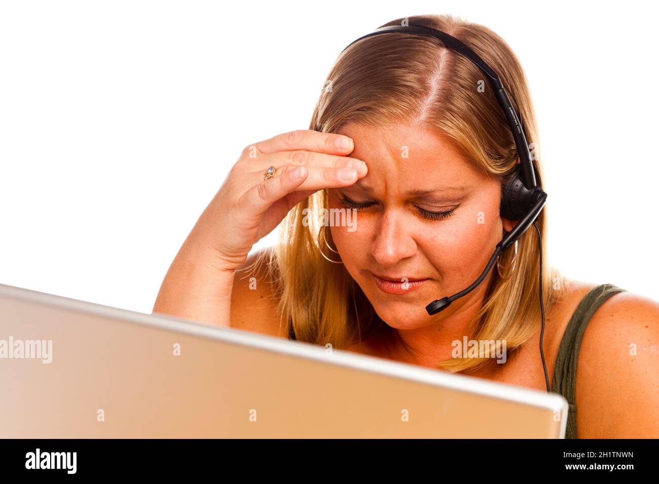 Businesswoman In Front of a Computer Screen with Phone Headset Showing Signs of Having a Bad