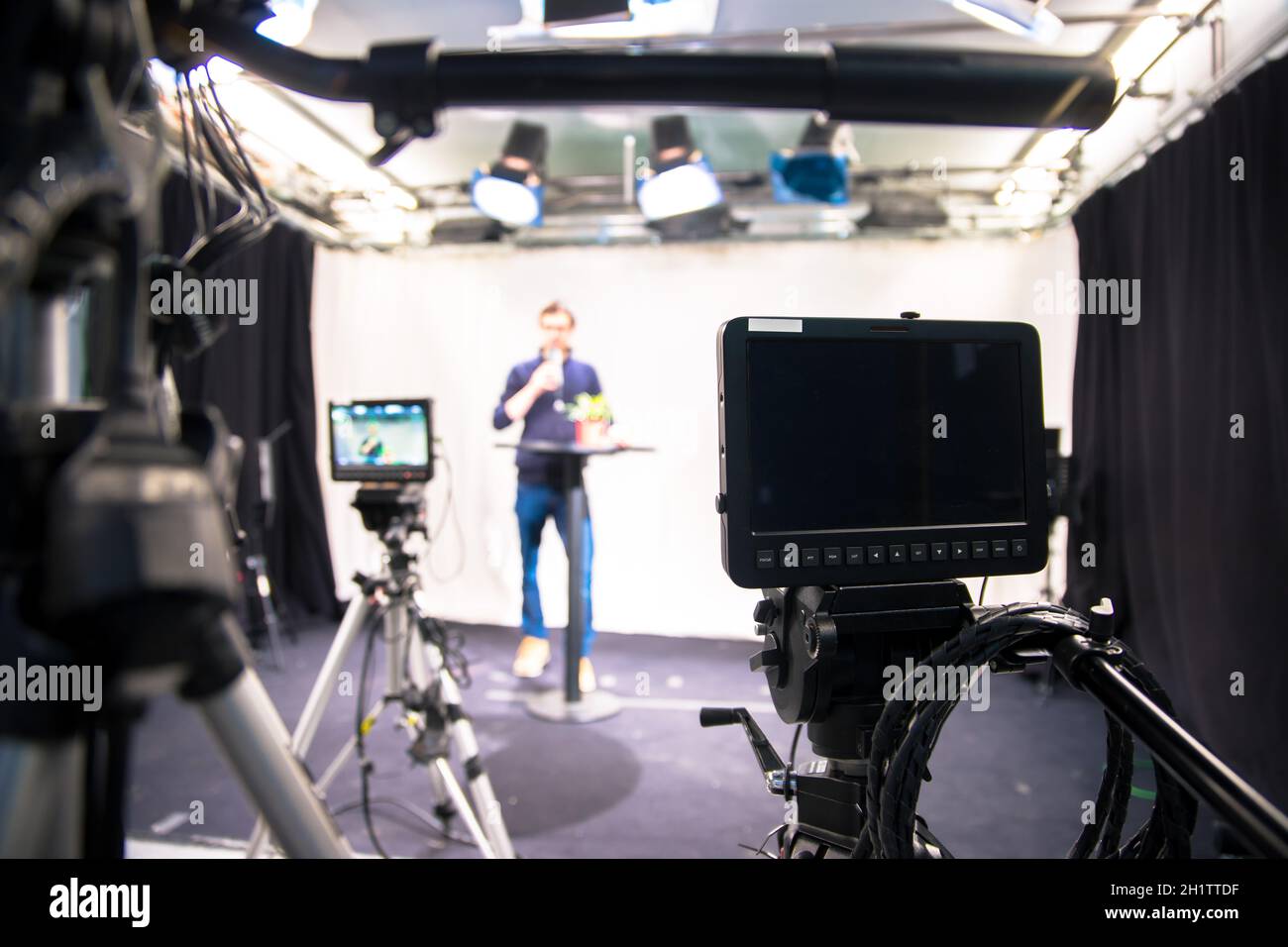 Male journalist in a television studio talks into a microphone, film