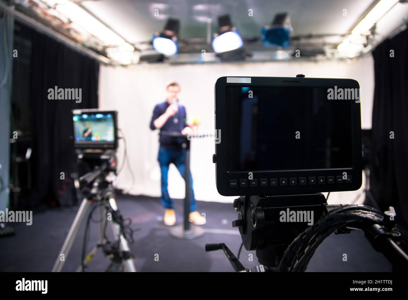 Male journalist in a television studio talks into a microphone, film