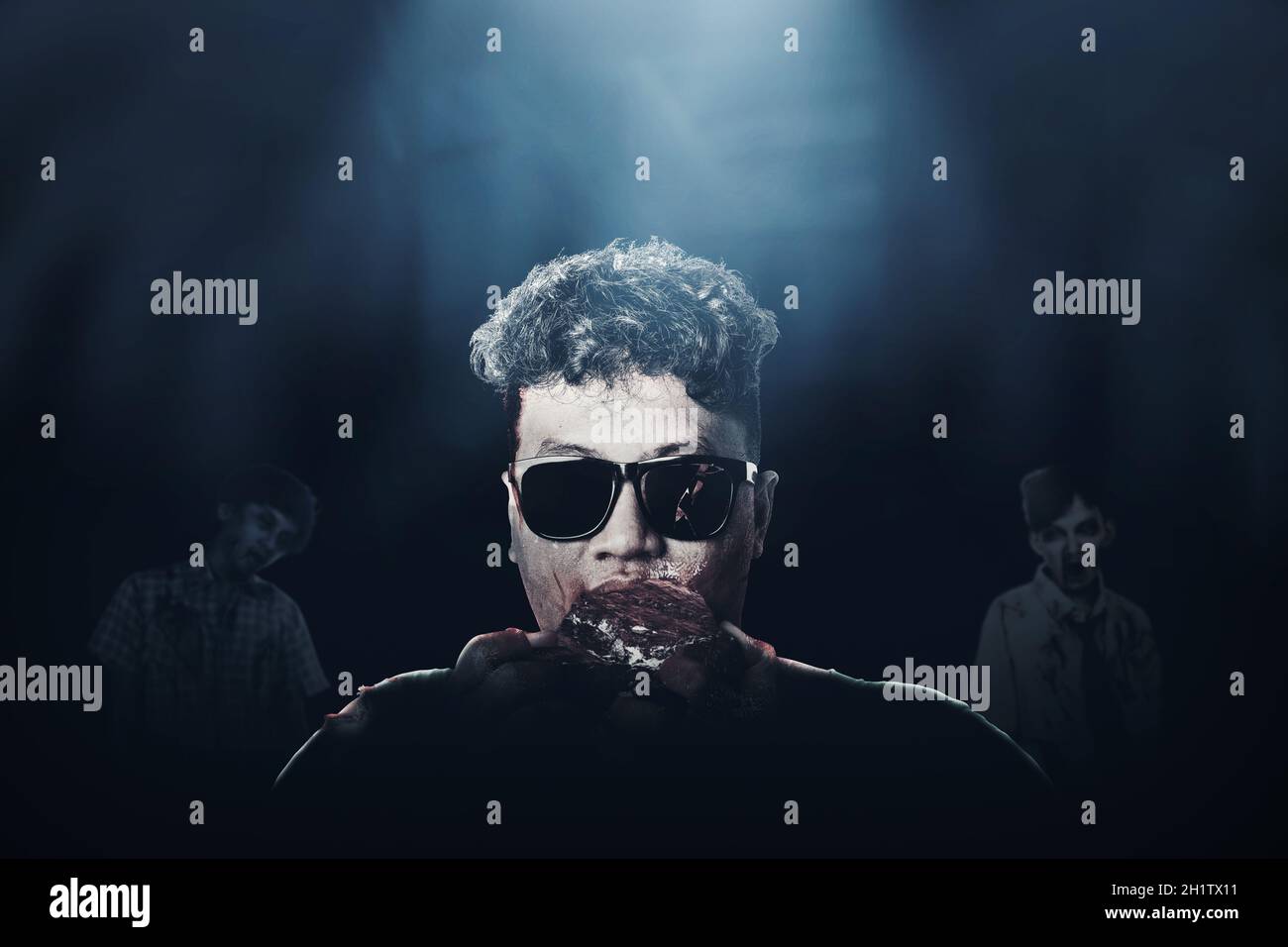 A scary zombie with blood and wound on his body eat the raw meat with