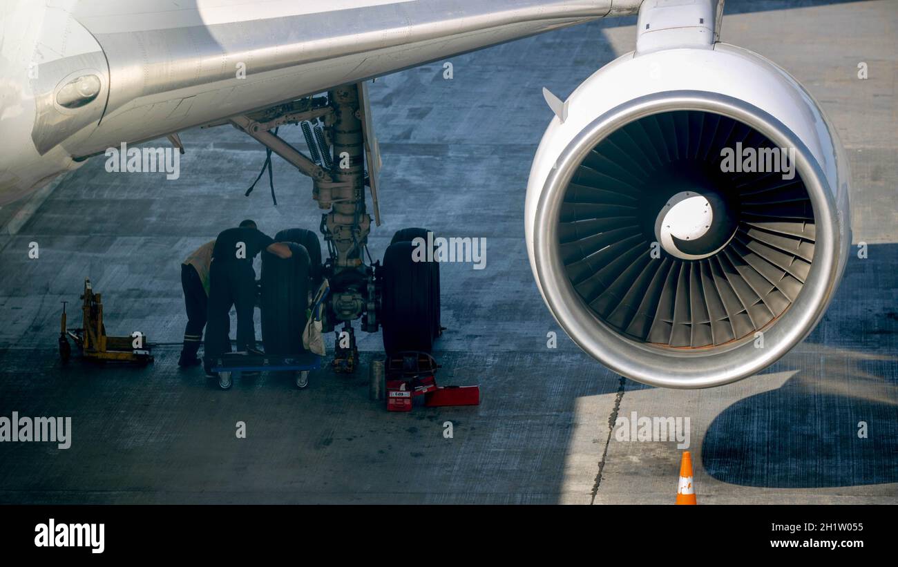 image of maintenace ground crew checking airplane chassis before flight Stock Photo