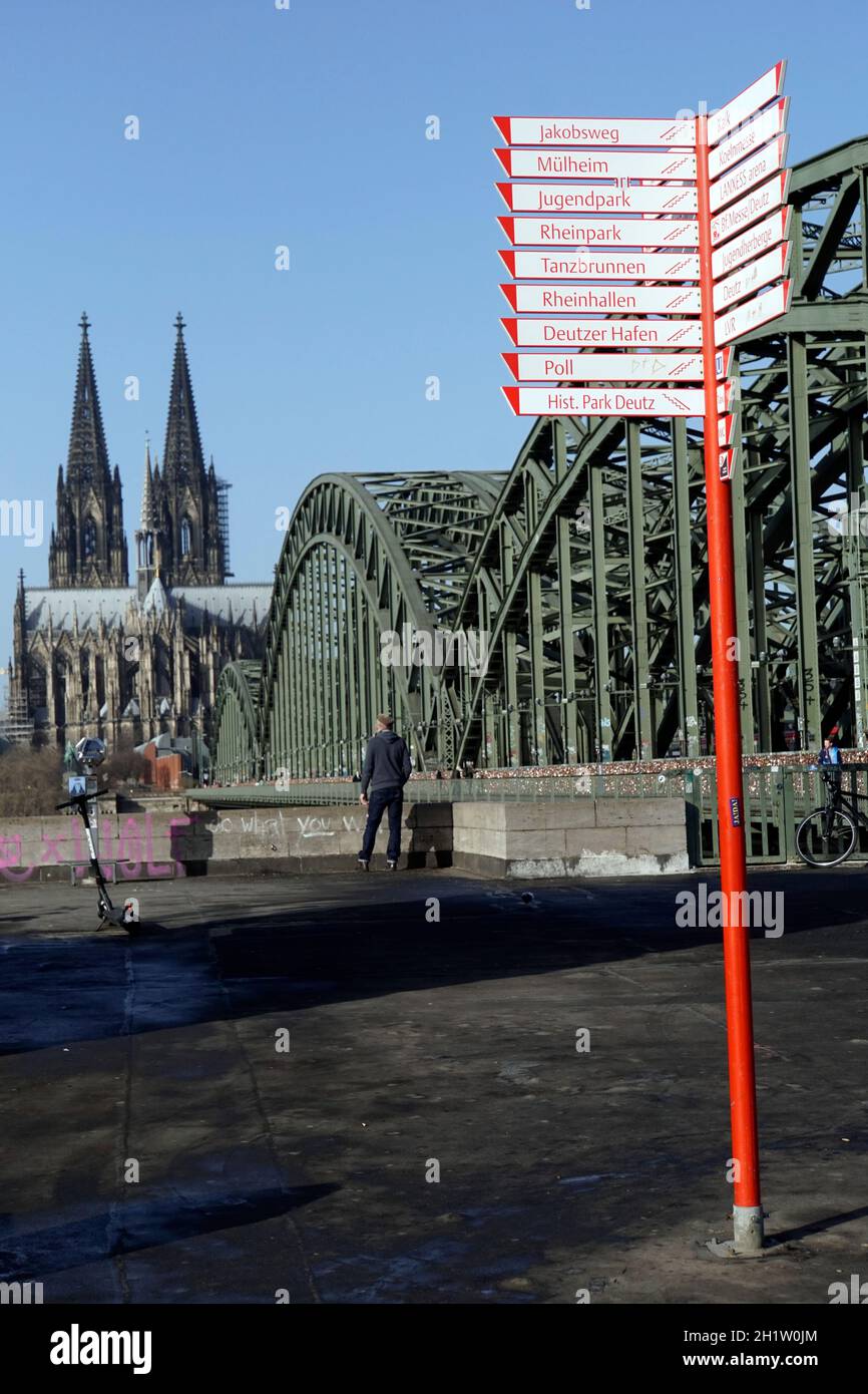 Fahrradwegweiser am Rheinufer, dahinter die Hohezollernbrücke und der Dom, Deutschland, Nordrhein-Westfalen, Köln-Deutz Stock Photo
