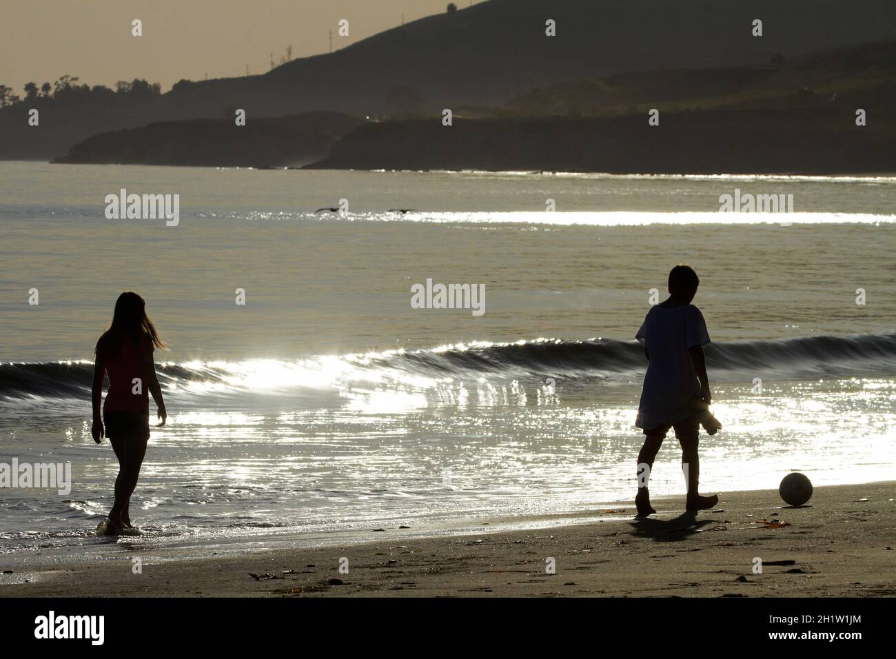 Children playing with football on El Capitan State Beach, Santa Barbara County, Central Coast, California, USA Stock Photo