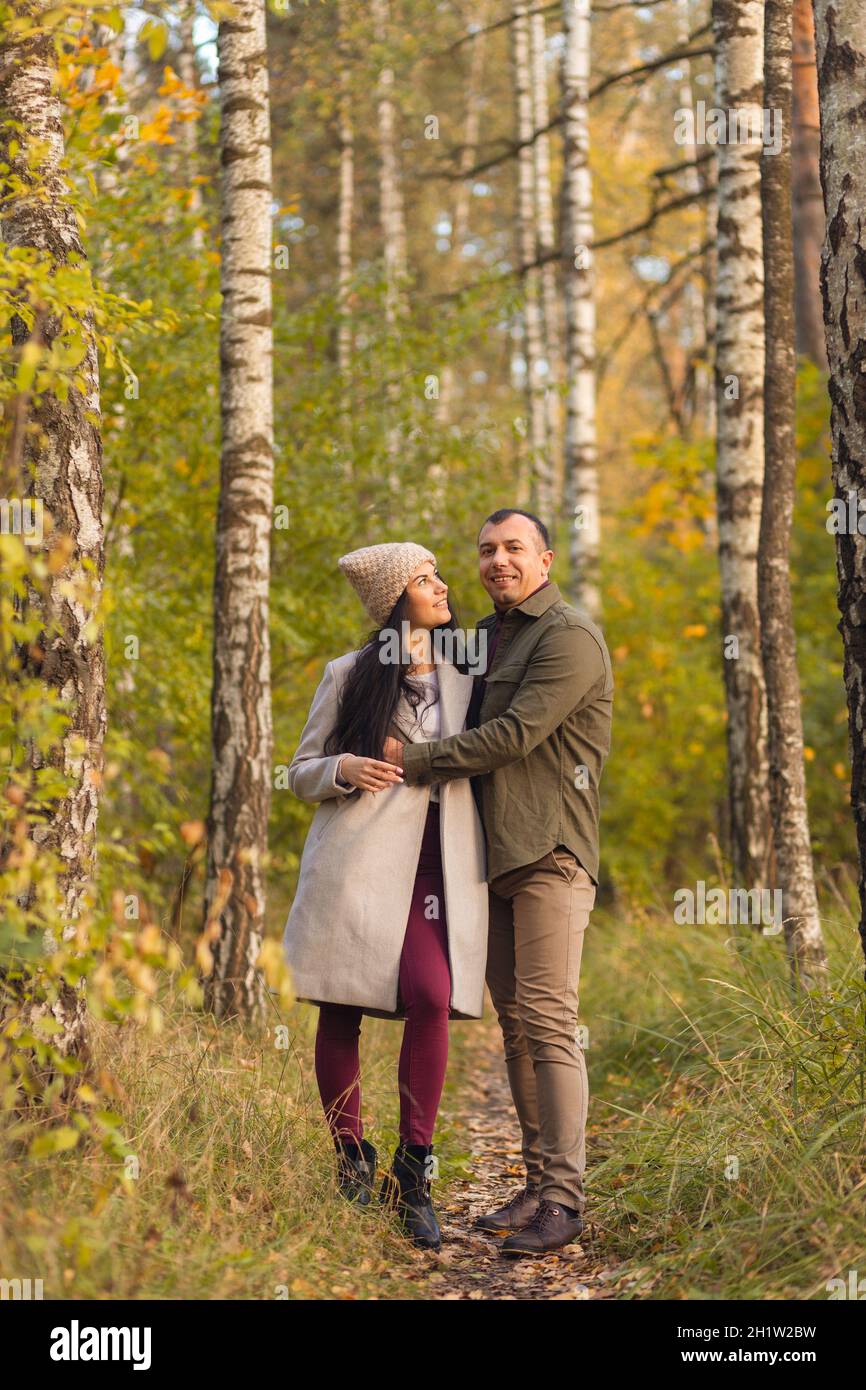 Lovely couple having fun together in nature. A young man and a woman embrace and pose in a birch grove in the golden autumn.. Holidays, love, travel, Stock Photo