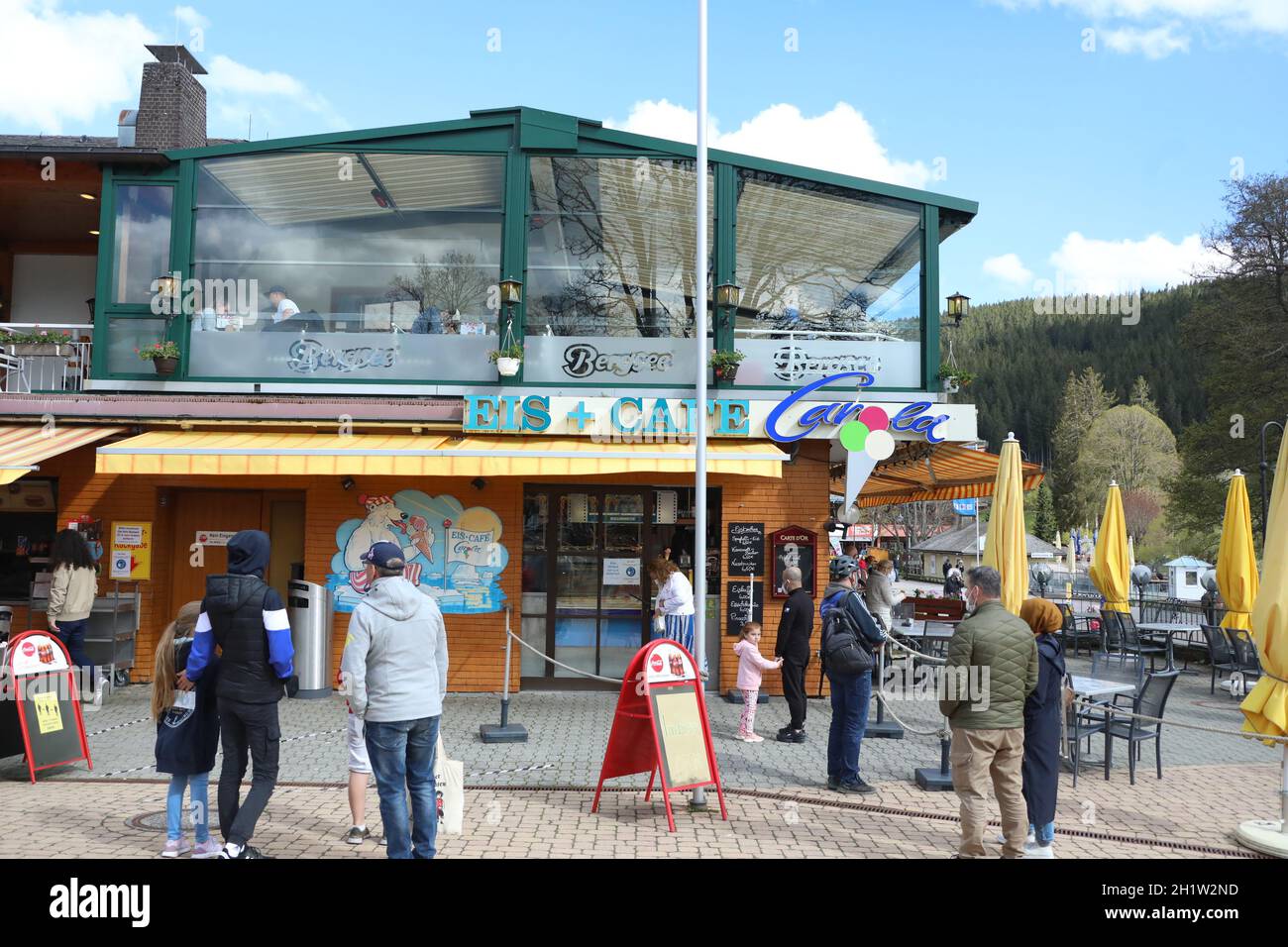 Mit Abstand und Mundschutz: Touristen an einem Eisstand am Titisee  An den Pfingstfeiertagen erfolgte auch im Hochschwarzwald in der Tourismusbranche Stock Photo