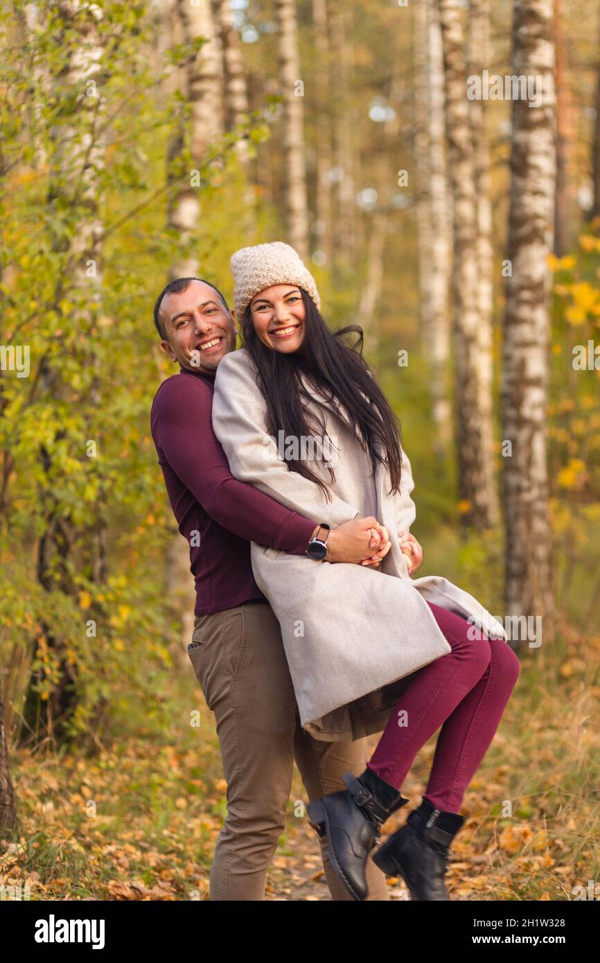Lovely couple having fun together in nature. A young man and a woman embrace and pose in a birch grove in the golden autumn.. Holidays, love, travel, Stock Photo