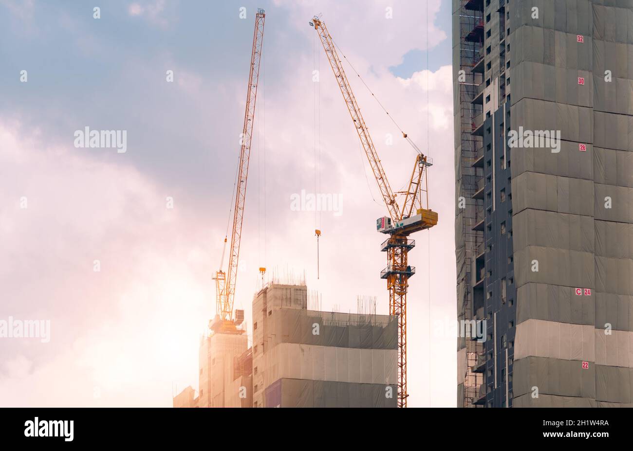 Construction site with crane and building. Real estate industry. Crane use reel lift up equipment in construction site. Apartment building constructio Stock Photo