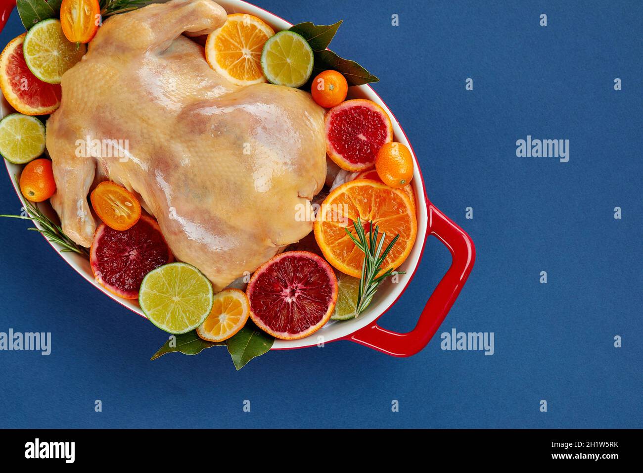 Herb and citrus oven roasted chicken. Whole chicken in roasting tin