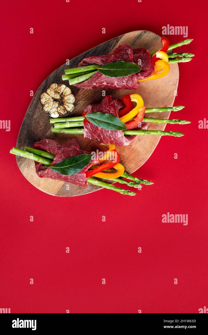 raw beef roulades and fresh vegetable trimmings ready for cooking on a