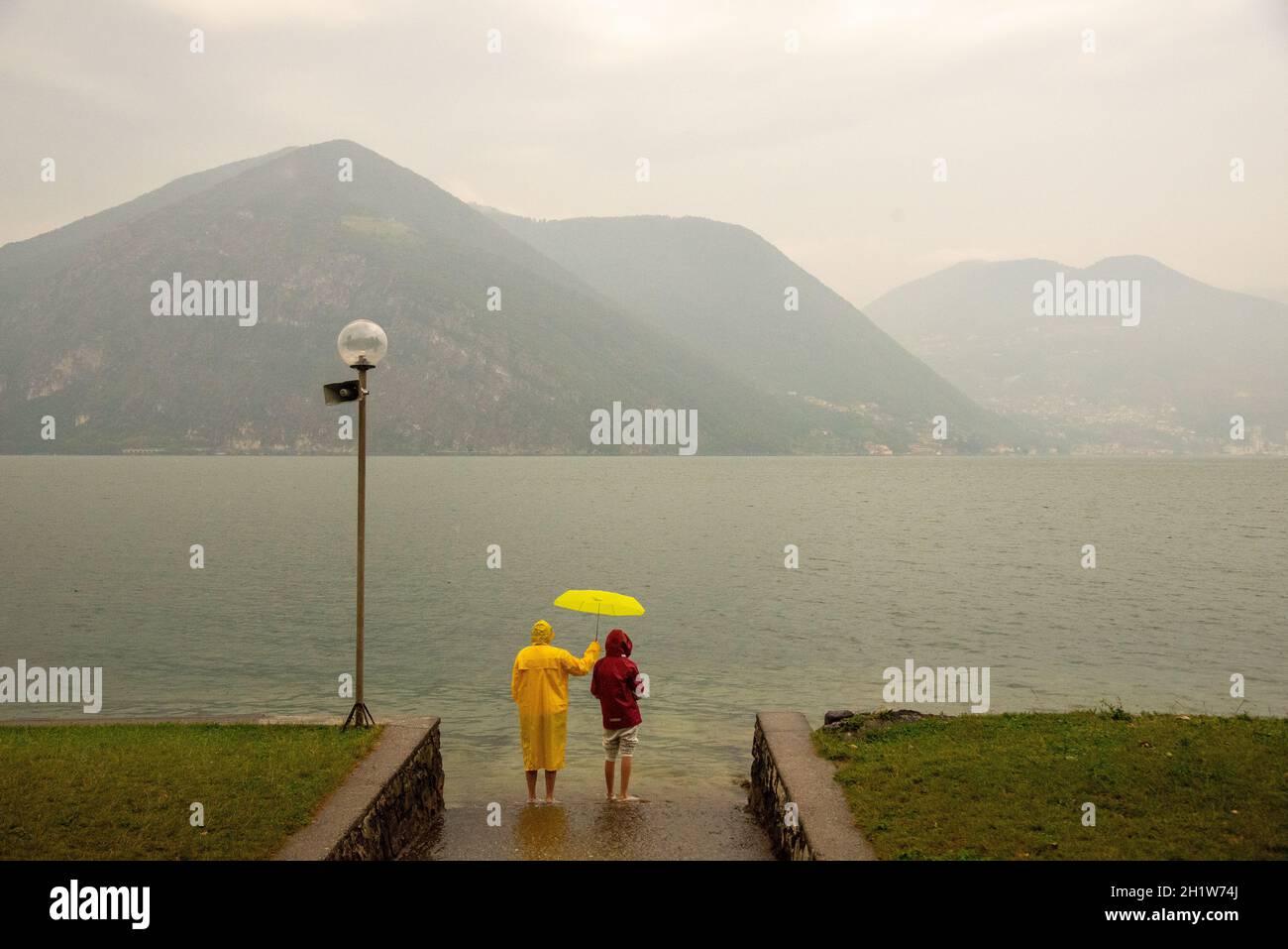 couple at Lake Iseo at a rainy day, Italy Stock Photo