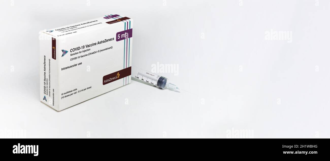 Cambridge, UK, february 5th 2021: A syringe next to the AstraZeneca Covid-19 Vaxzevria vaccine box isolated on a white background. Health and preventi Stock Photo