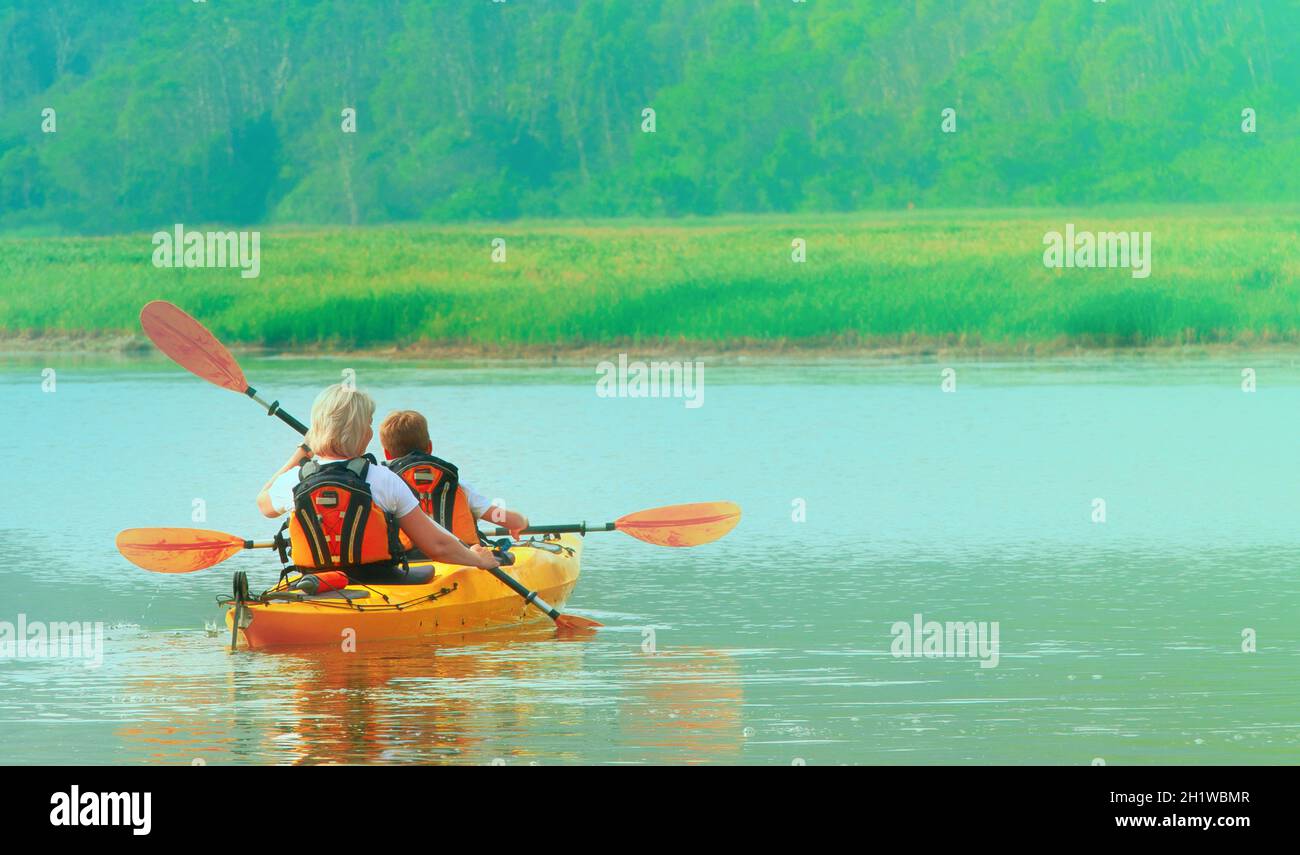 The Kayaking and canoeing with family. The woman with a child on the lake and ride on kayak Stock Photo