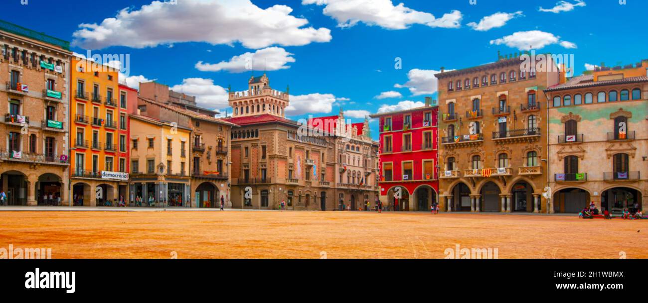 The blurred Plaza Mayor in Vic on a sunny day filled with tourists, Catalonia, Spain. Selective focus Stock Photo