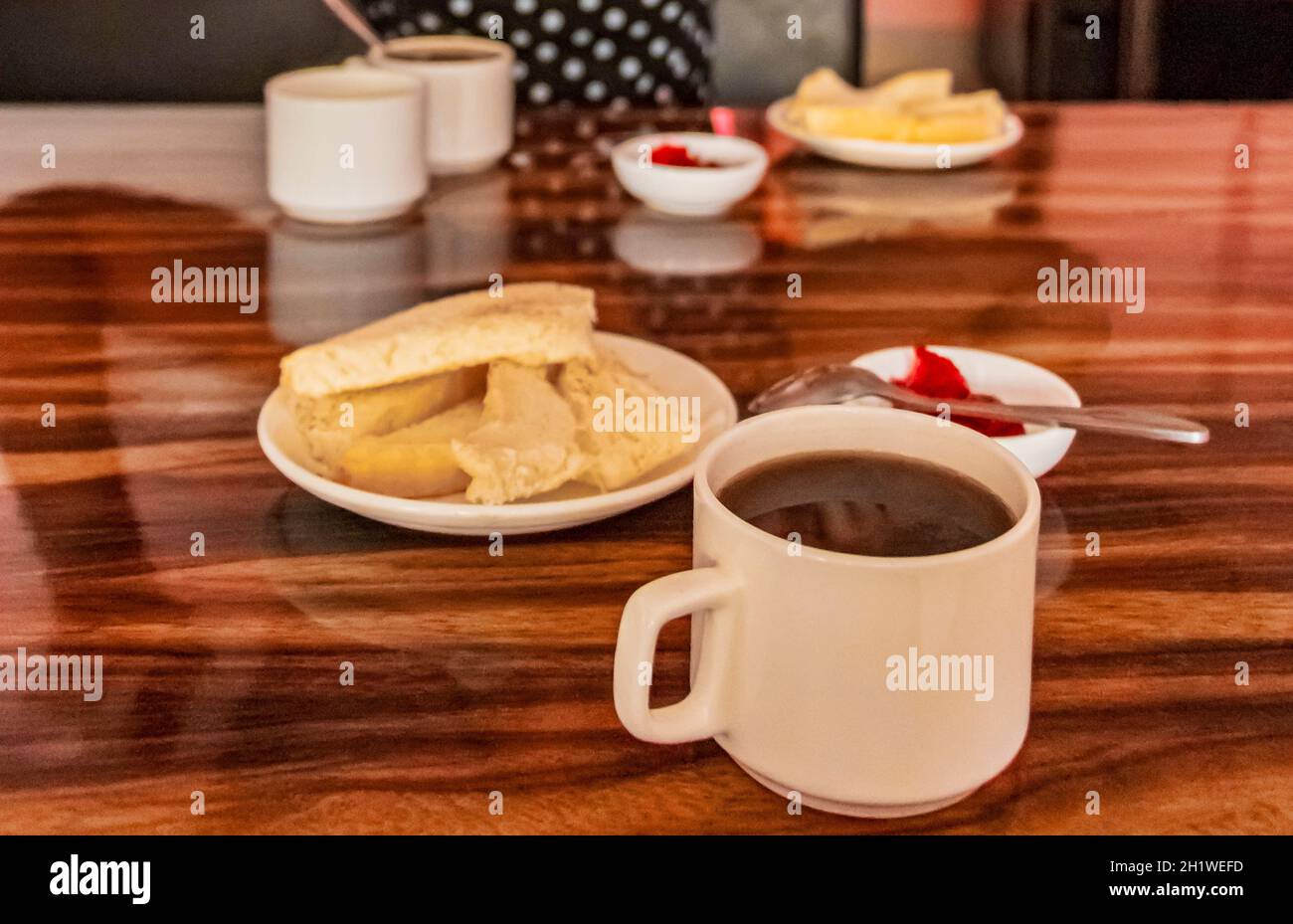 Simple hotel hostel breakfast with toast jam butter and black coffee on