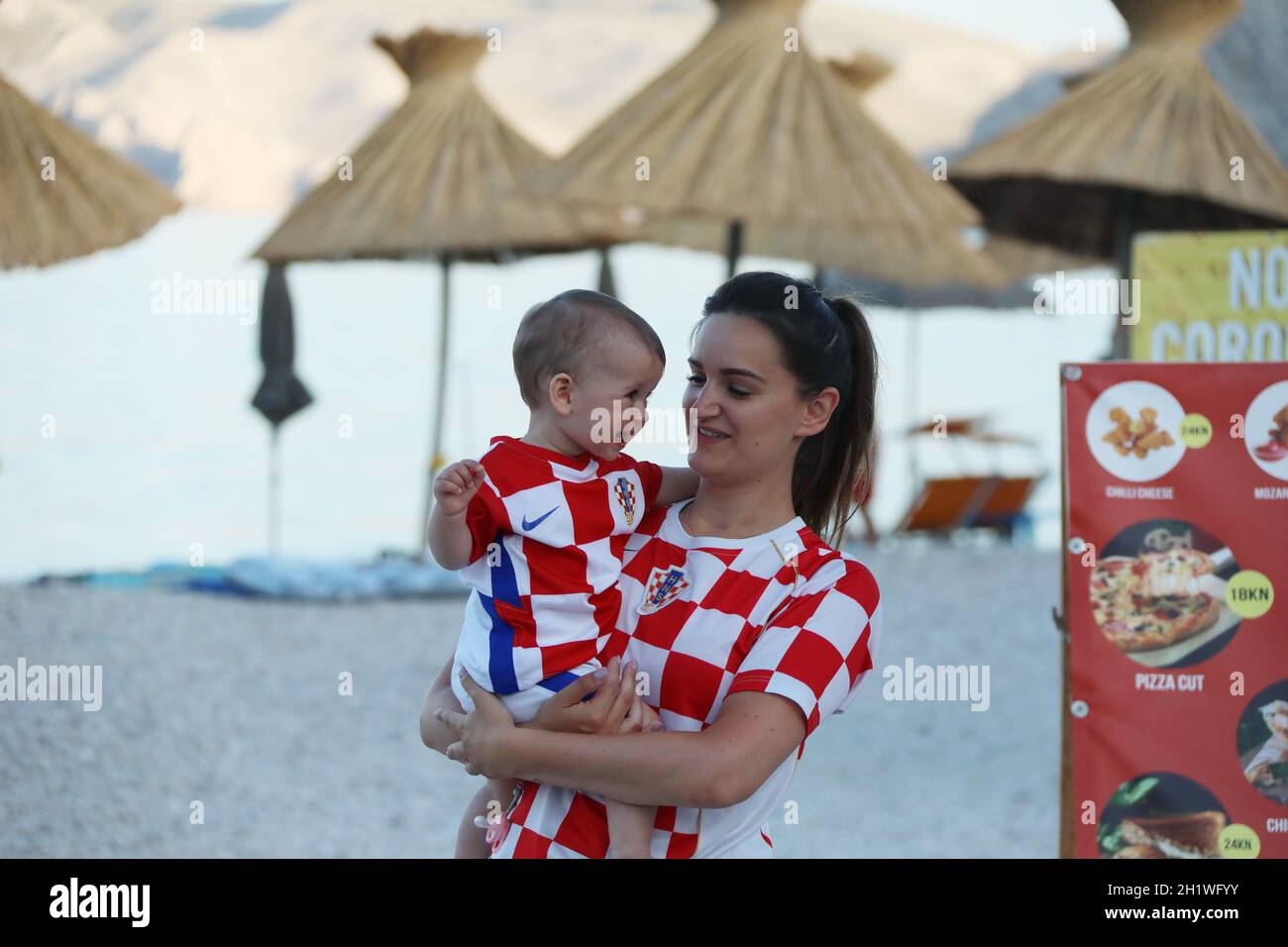 Mutter und Kind in der Strandbar hatten bei der Live-Übertragung der Fussball-EM: Achtelfinale Kroatien vs Spanien trotz des Ausscheidens der eigenen Stock Photo