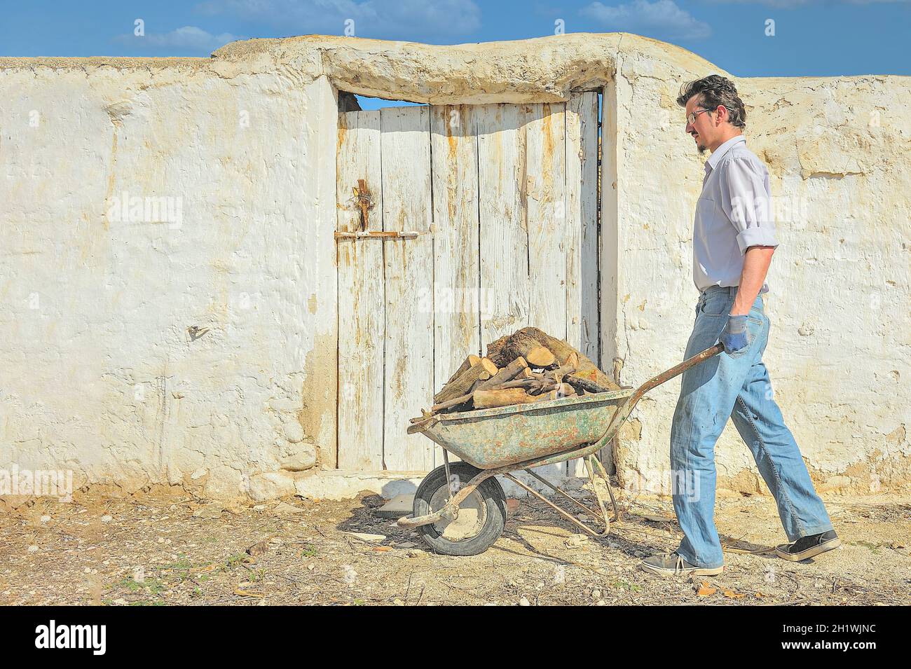 Transporting firewood in a rural village, with an old wheelbarrow Stock ...