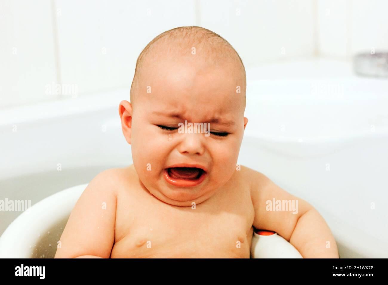 Crying baby taking bath. Baby does not want bathing Stock Photo Alamy