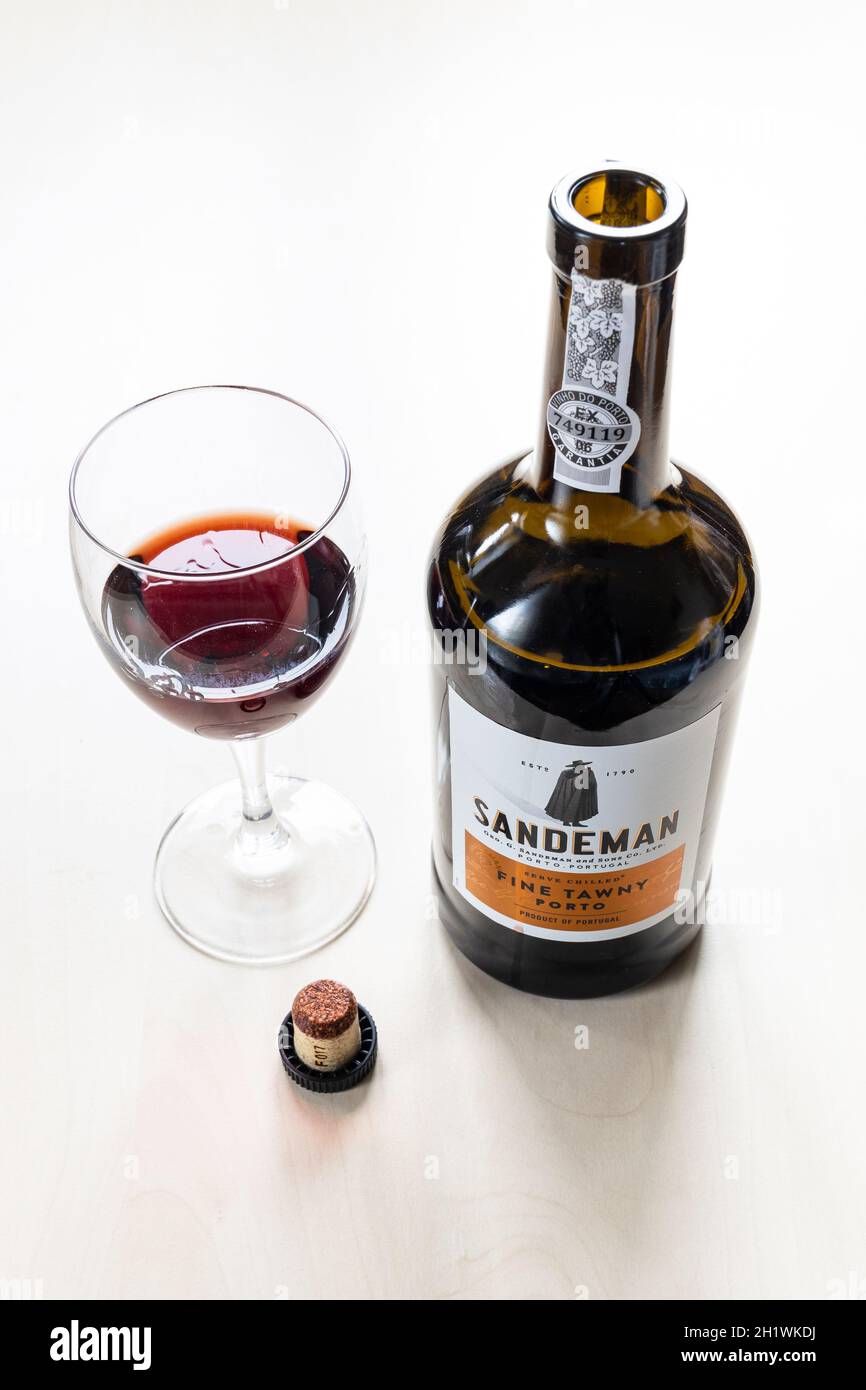 MOSCOW, RUSSIA - JUNE 10, 2021: wine glass, cork and open bottle of Sandeman fine tawny porto wine. Sandeman is brand of Port and Sherry wines founded Stock Photo