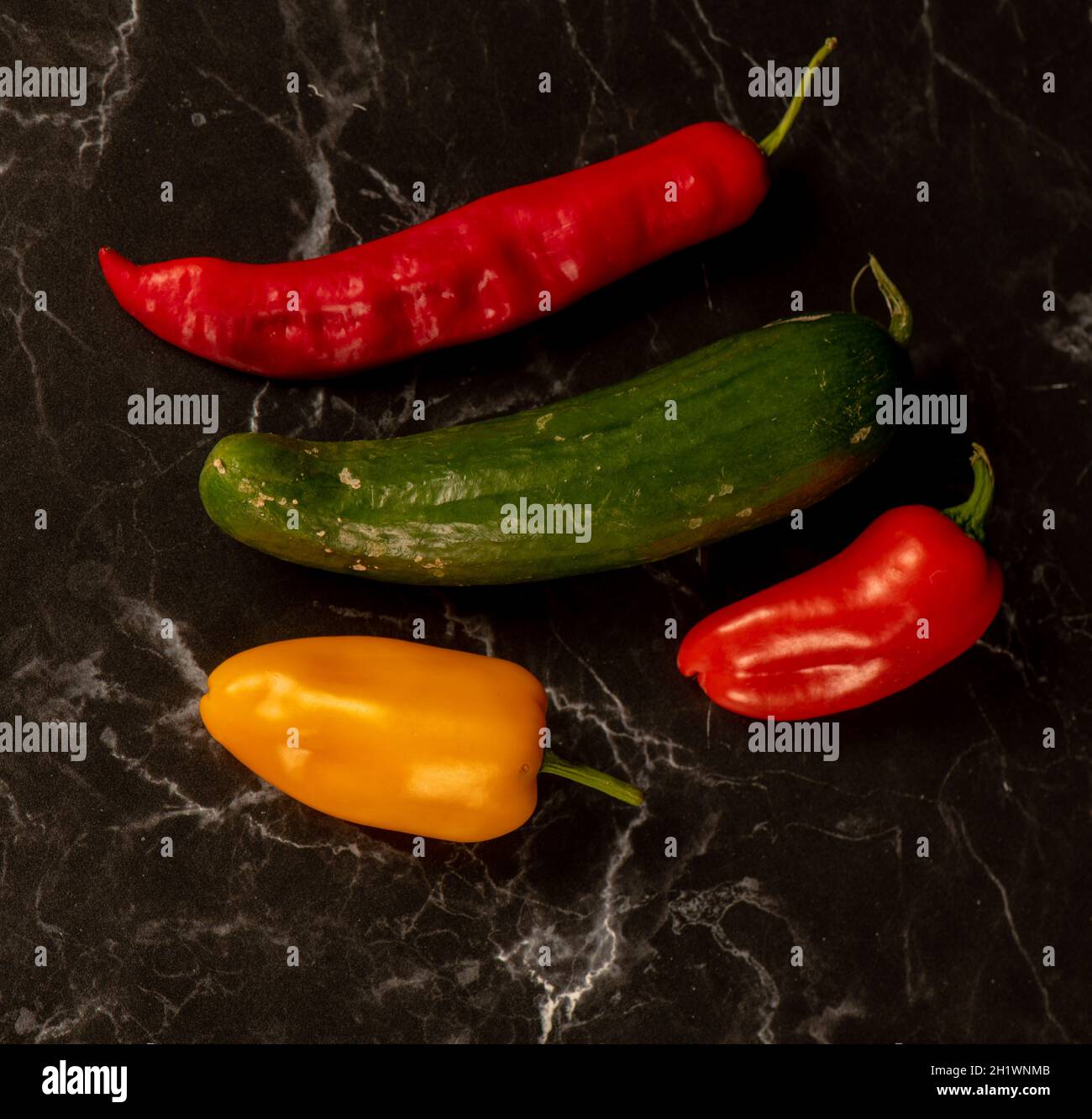 Still life of red, green and yellow peppers, all freshly grown natural produce. Stock Photo