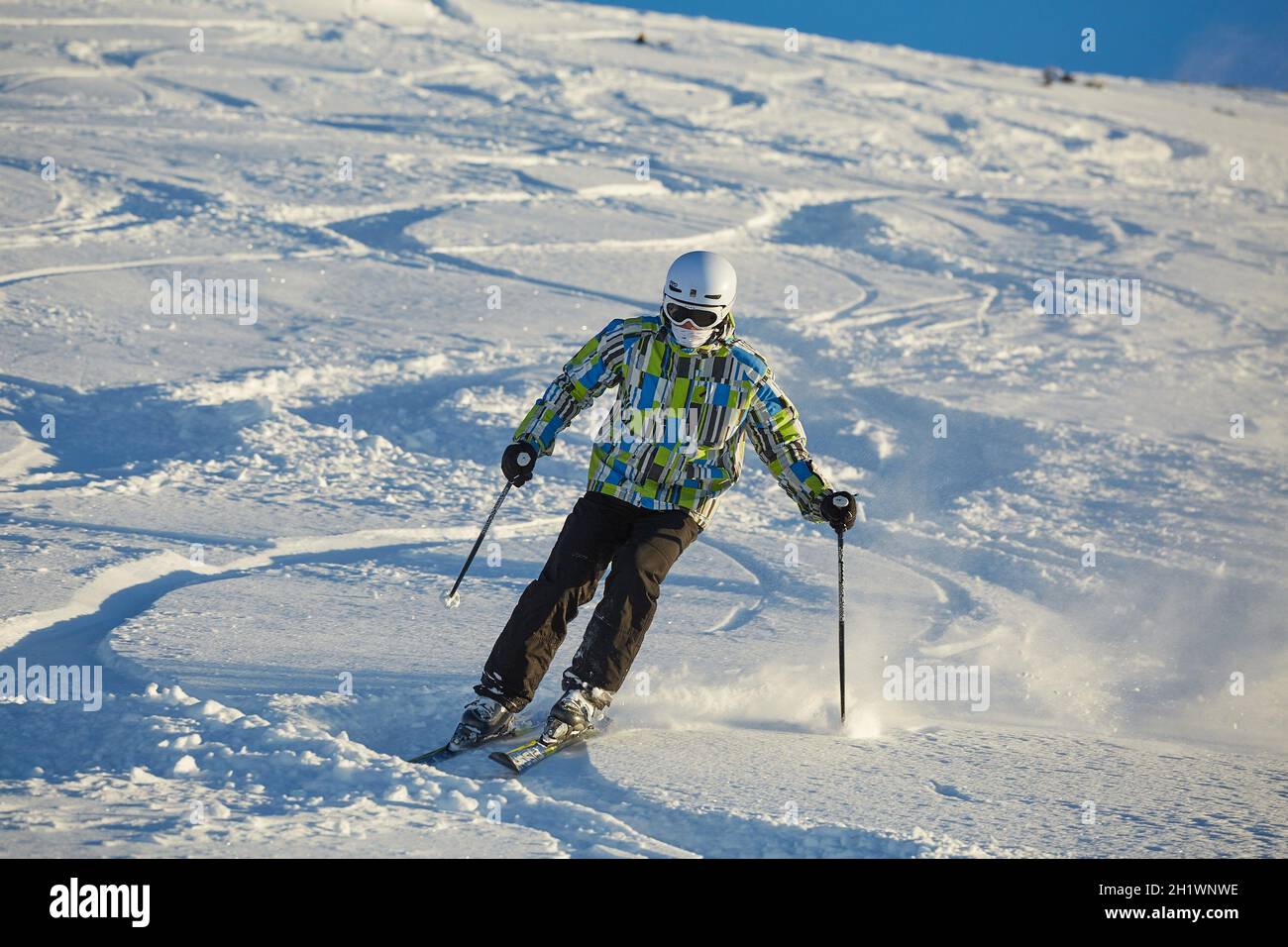 LES ORRES, FRANCE - JANUARY 23, 2015: Young skier coming down fast in fresh powder snow off-piste. Stock Photo