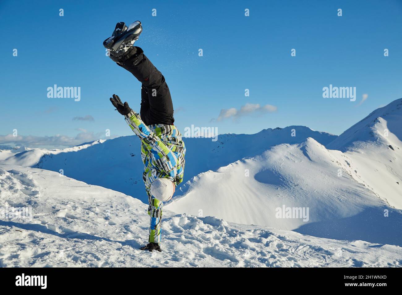 LES ORRES, FRANCE - JANUARY 23, 2015: Young skier coming doing hand stand on the top of the mountain Stock Photo