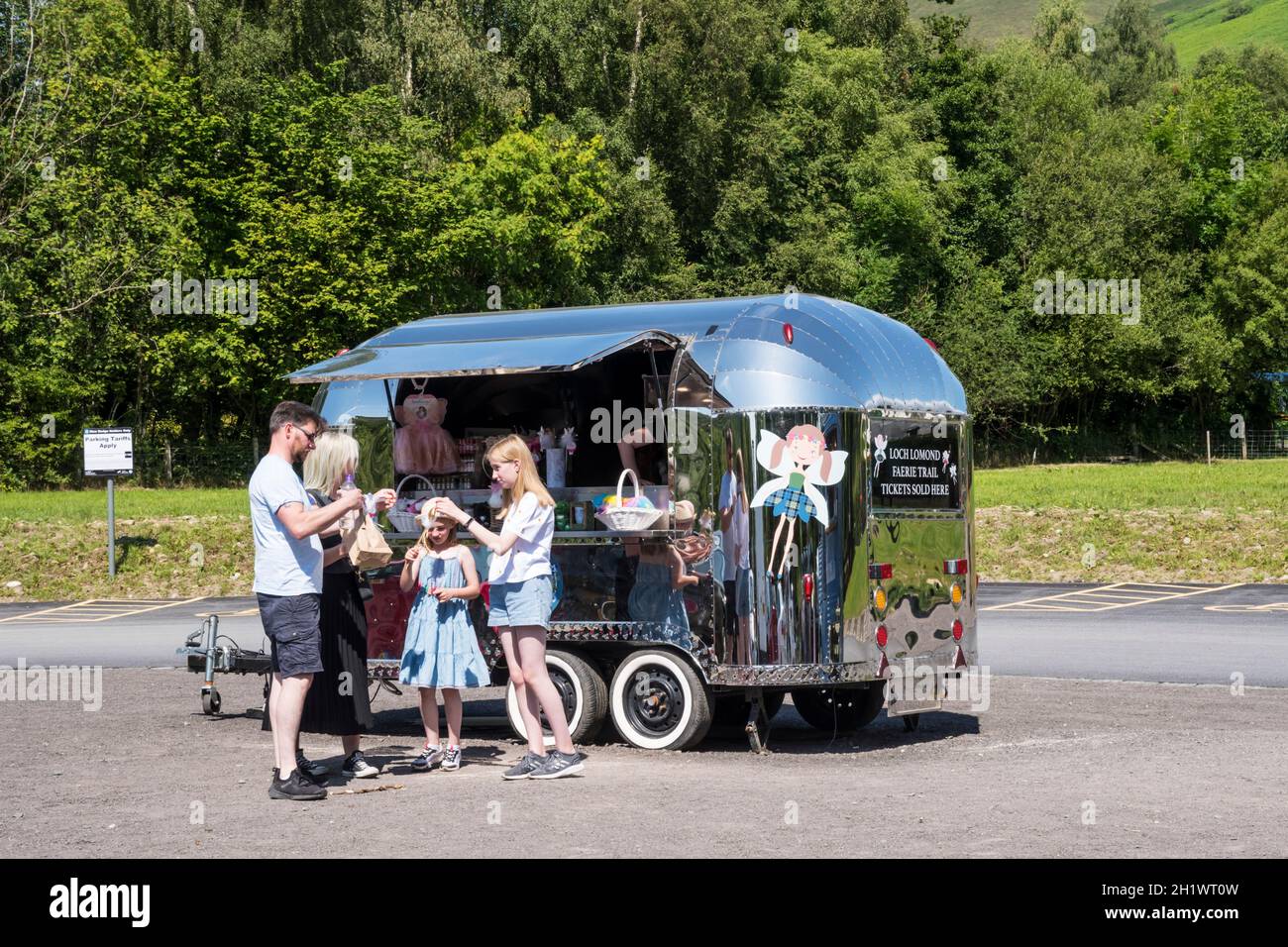 People outside the ticket office caravan for the Loch Lomond Faerie Trail in Luss. Stock Photo