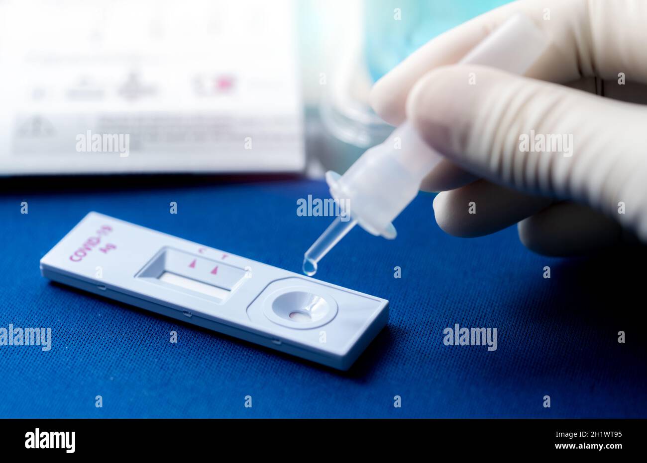 Hand holding sample tube and drops in the test device of covid 19