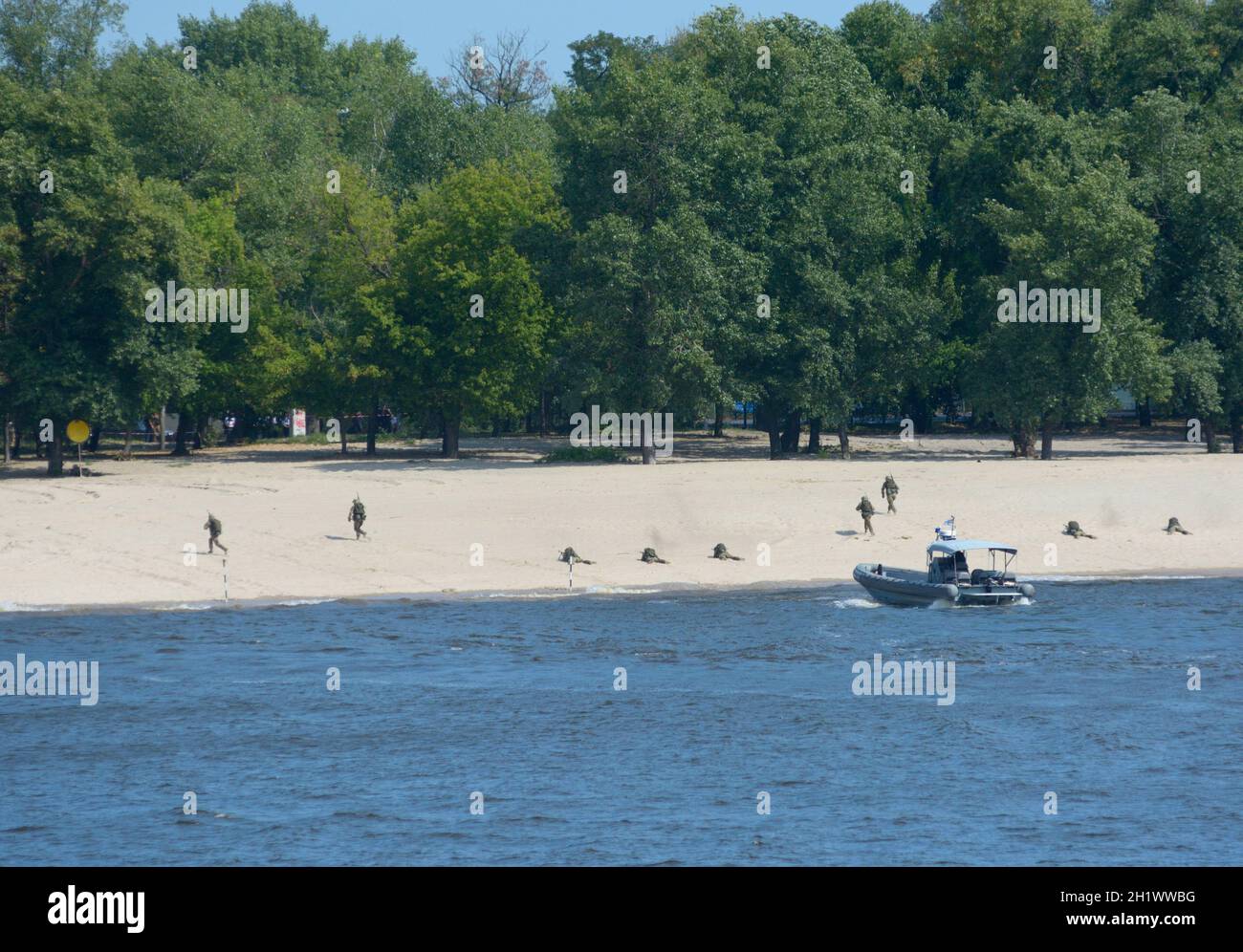 Soldiers of Seaborne special forces disembarking on sandy beach from an amphibious personnel carrier attacking enemy. Military parade dedicated to Ind Stock Photo