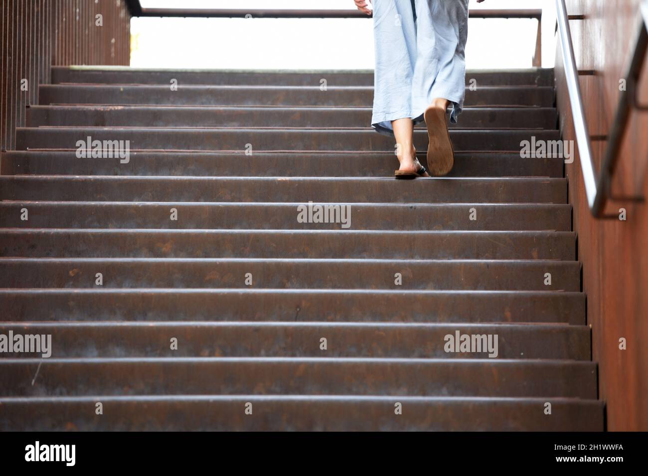 Eine Frau in sommerlicher Kleidung geht auf einer Stiege hinauf, Österreich, europa - A woman in summer clothes goes up a staircase, Austria, Europe Stock Photo