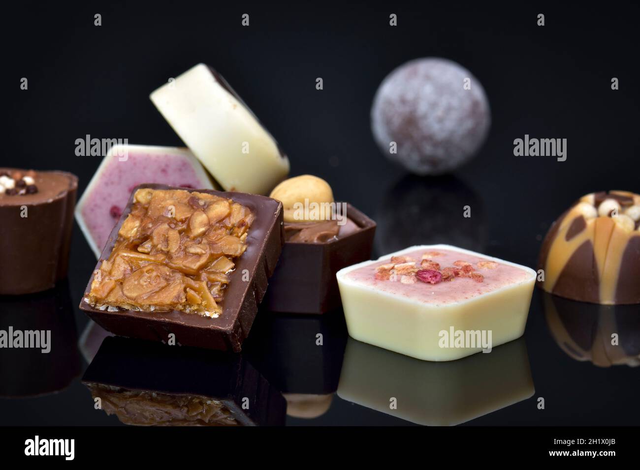 Close up of luxury continental or Belgian assorted chocolates on black background Stock Photo