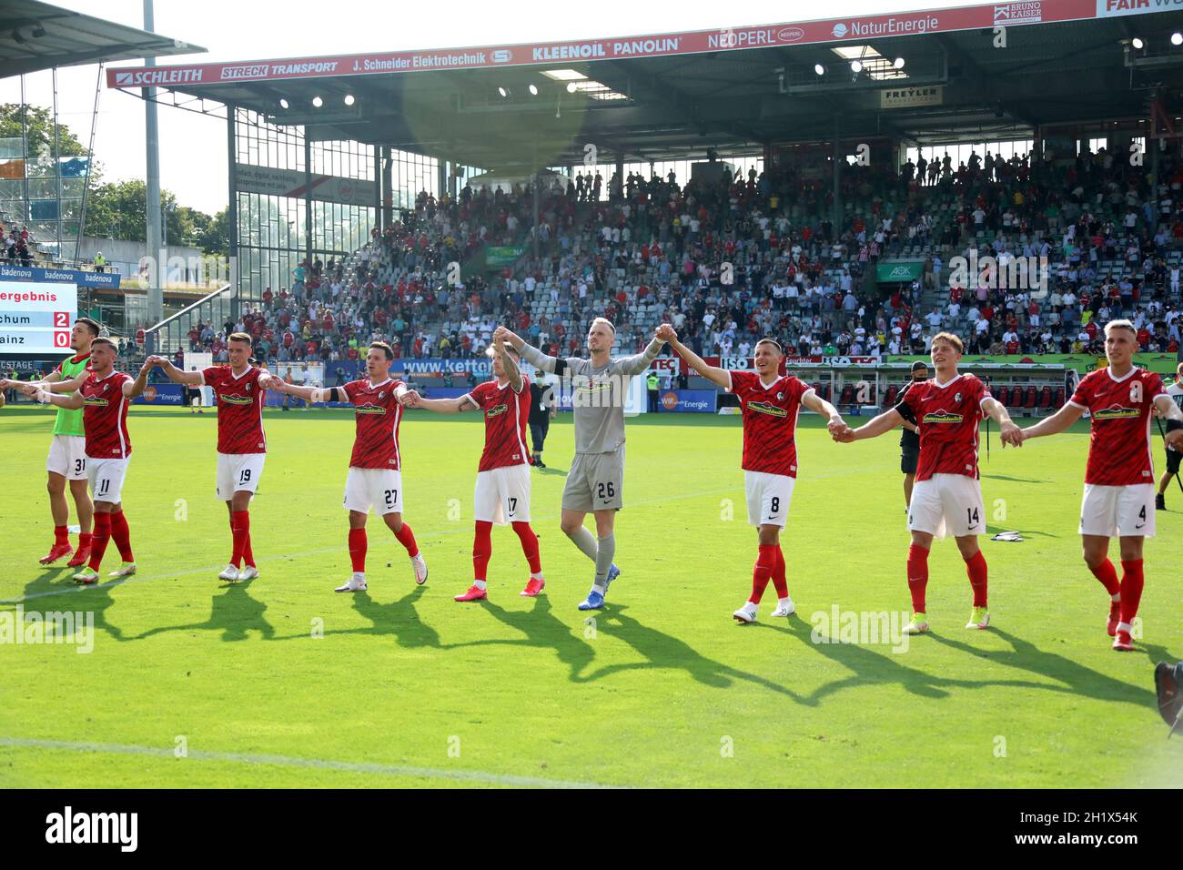 Hand in Hand mit den Fans feiern - die Freiburger Spieler nach dem 2:1 Sieg gegen Dortmund vor der Osttribüne,   1. FBL: 21-22: 2. Sptg. SC Freiburg - Stock Photo