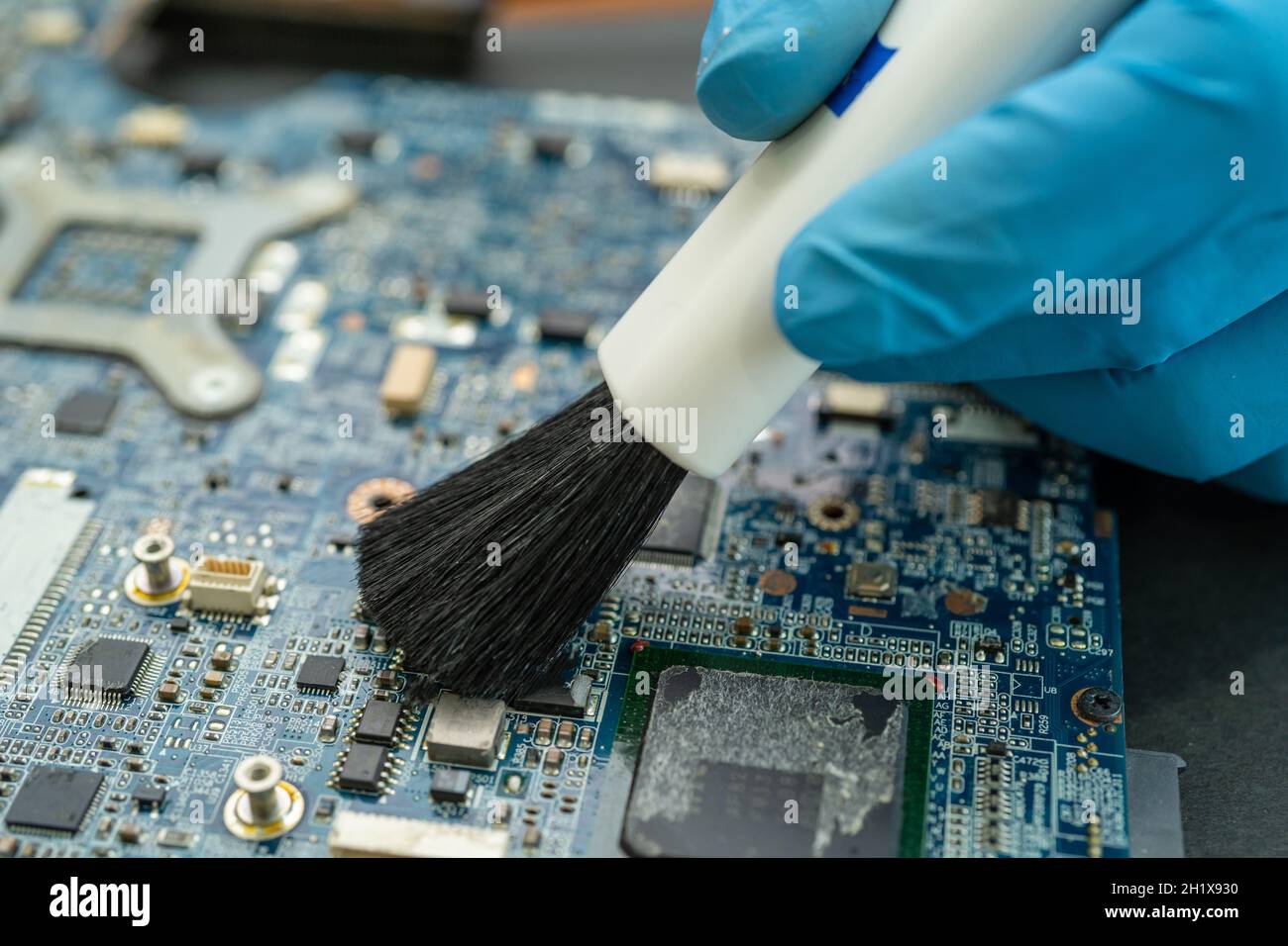 Technician use brush and air blower ball to clean dust in circuit board