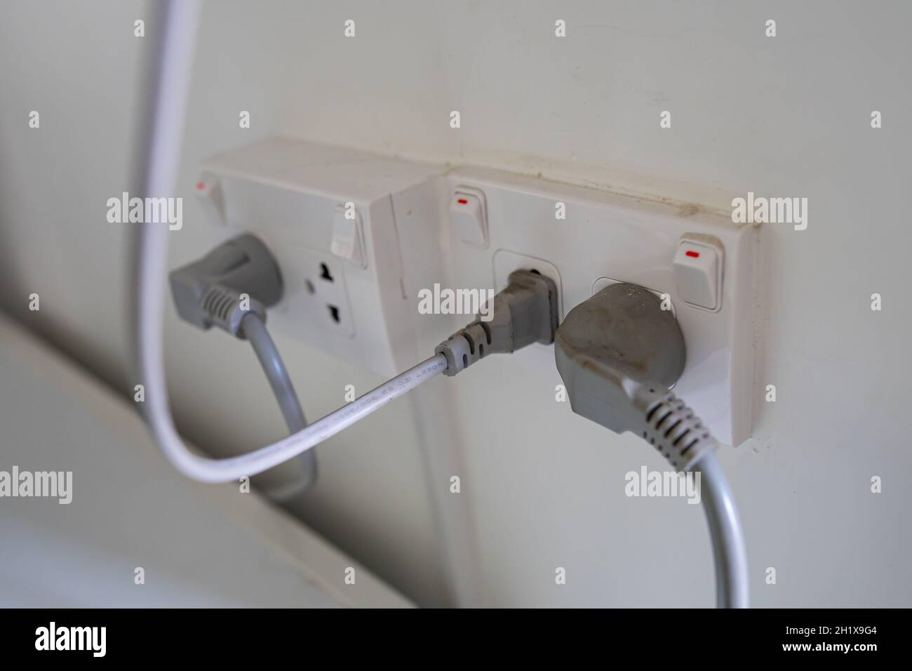 Power cable electric plug on wall at house. Stock Photo