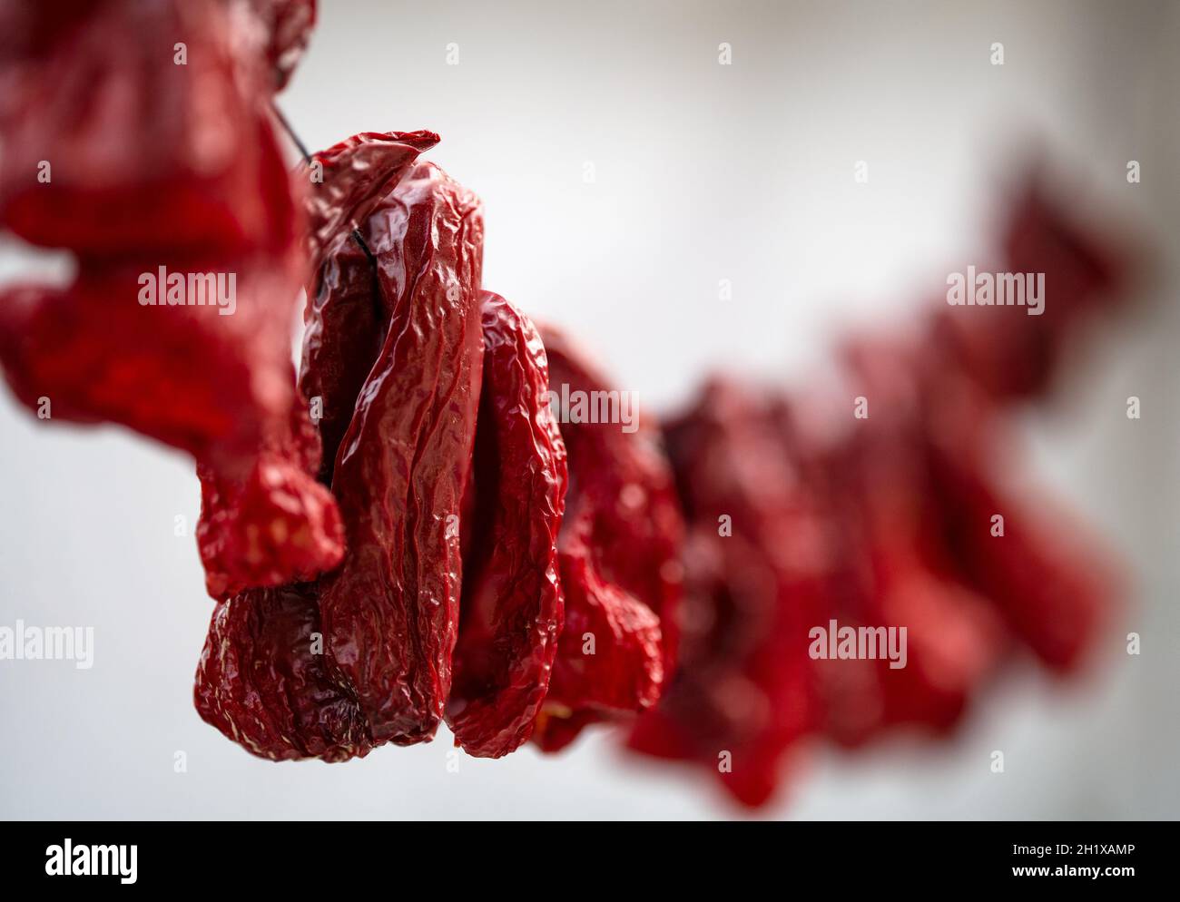 Red peppers hanging to be dried. Selective focus Stock Photo