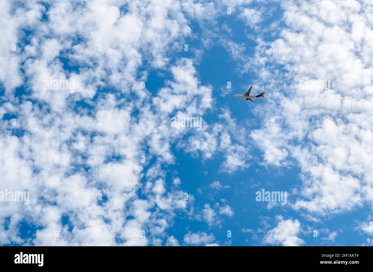 MADRID, SPAIN - JULY 25, 2021: An airplane of the Spanish airline Iberia on a blue sky with white clouds background, after departing from Madrid airpo Stock Photo