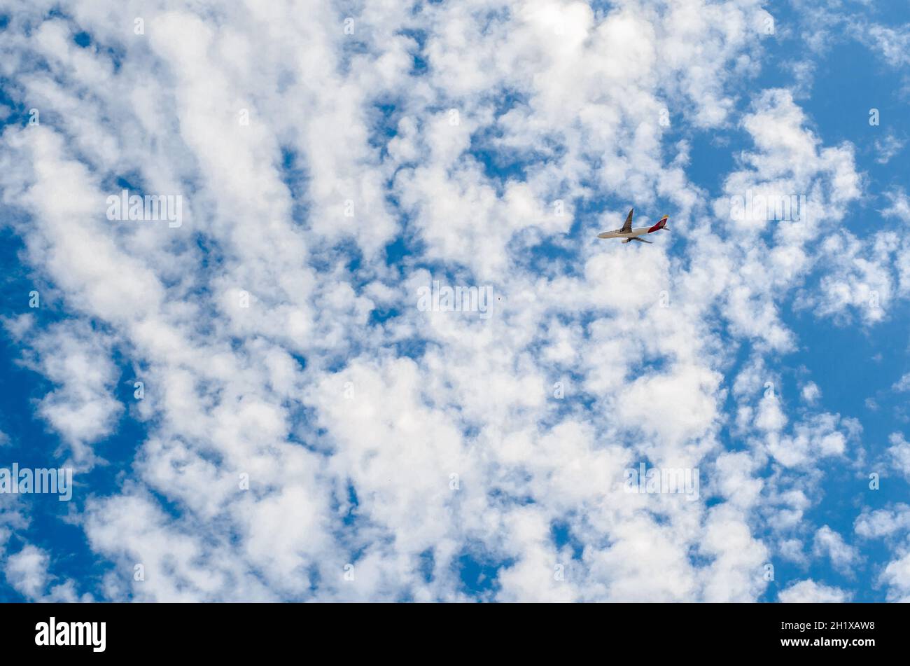 MADRID, SPAIN - JULY 25, 2021: An airplane of the Spanish airline Iberia on a blue sky with white clouds background, after departing from Madrid airpo Stock Photo