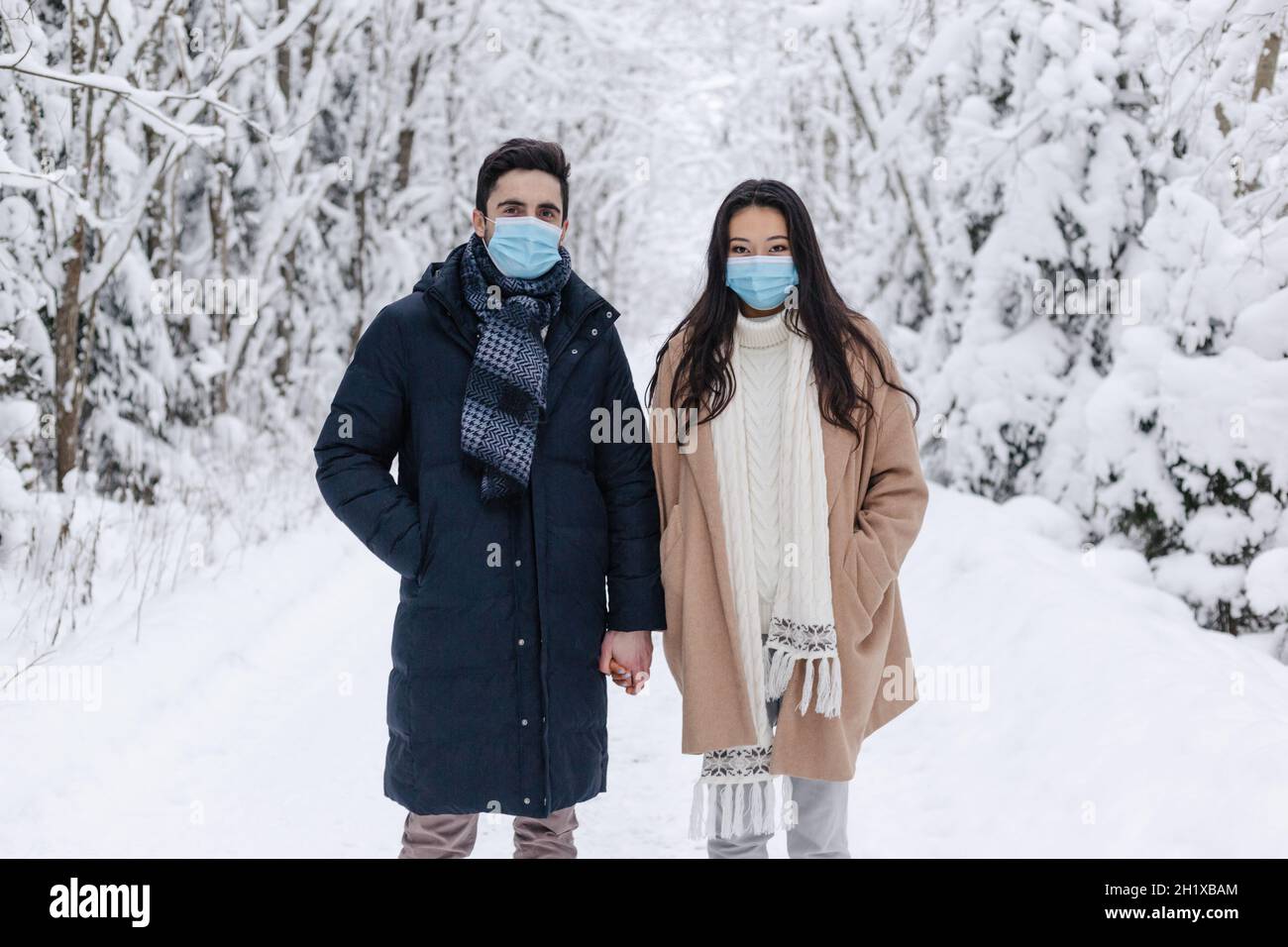 Couple Wearing Medical Mask in Winter Nature. Love Story Shoot in Nature. Cute Couple, Health Care Concept. Couple in Medical Masks Stock Photo
