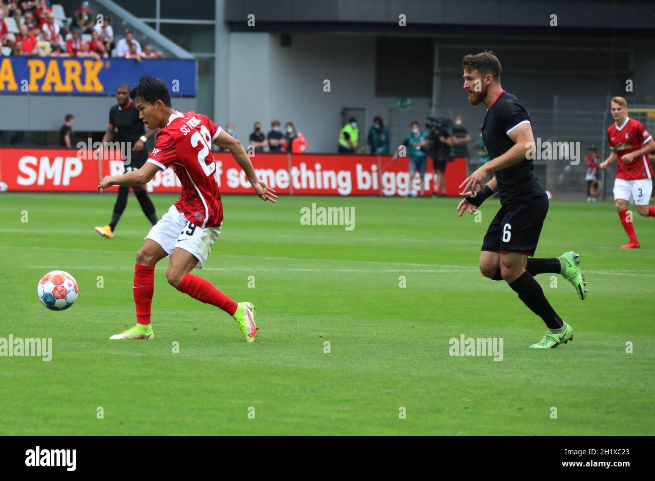 Woo-Yeong Jeong (SC Freiburg) ist mit Ball einen Schritt schneller als Salih Özcan (Koeln) beim Spiel der 1. FBL: 21-22: 4. Sptg. SC Freiburg vs 1. FC Stock Photo