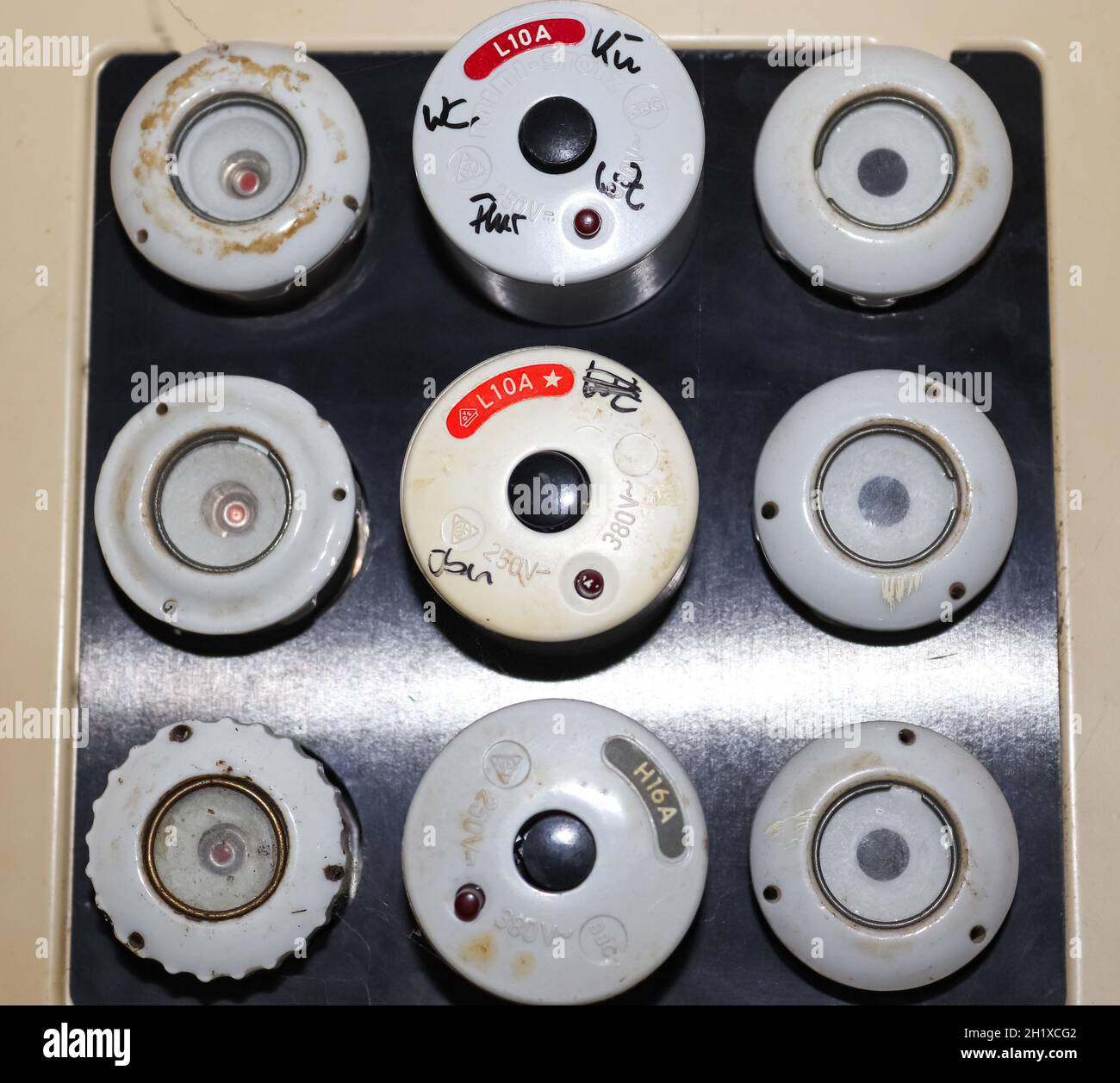 Old fuse box with ceramic fuses and some handwritings on it Stock Photo