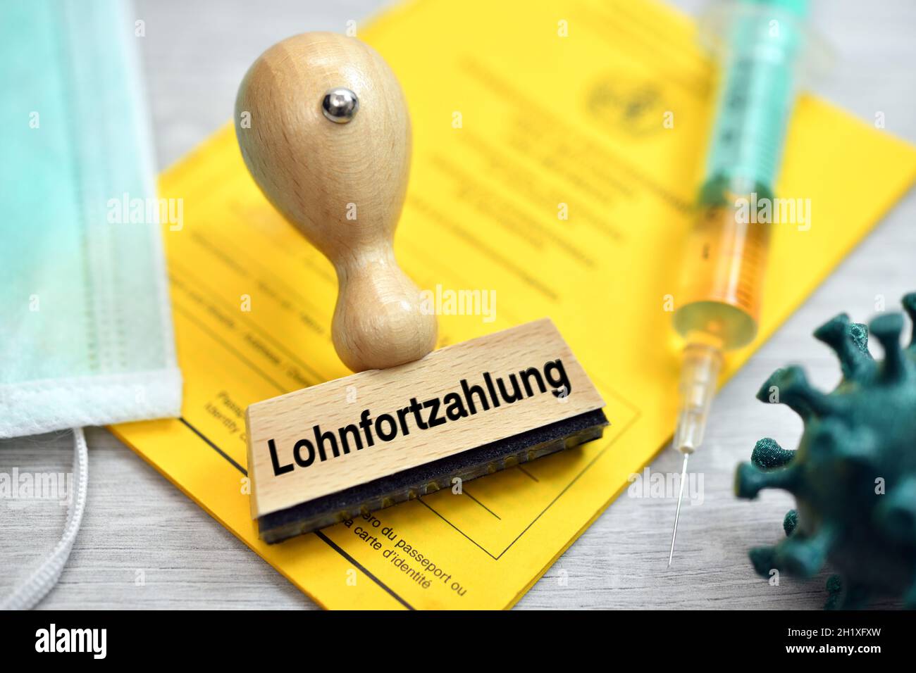 German Word For Continued Payment Of Wages On Stamp Lying On A Vaccination Card Stock Photo